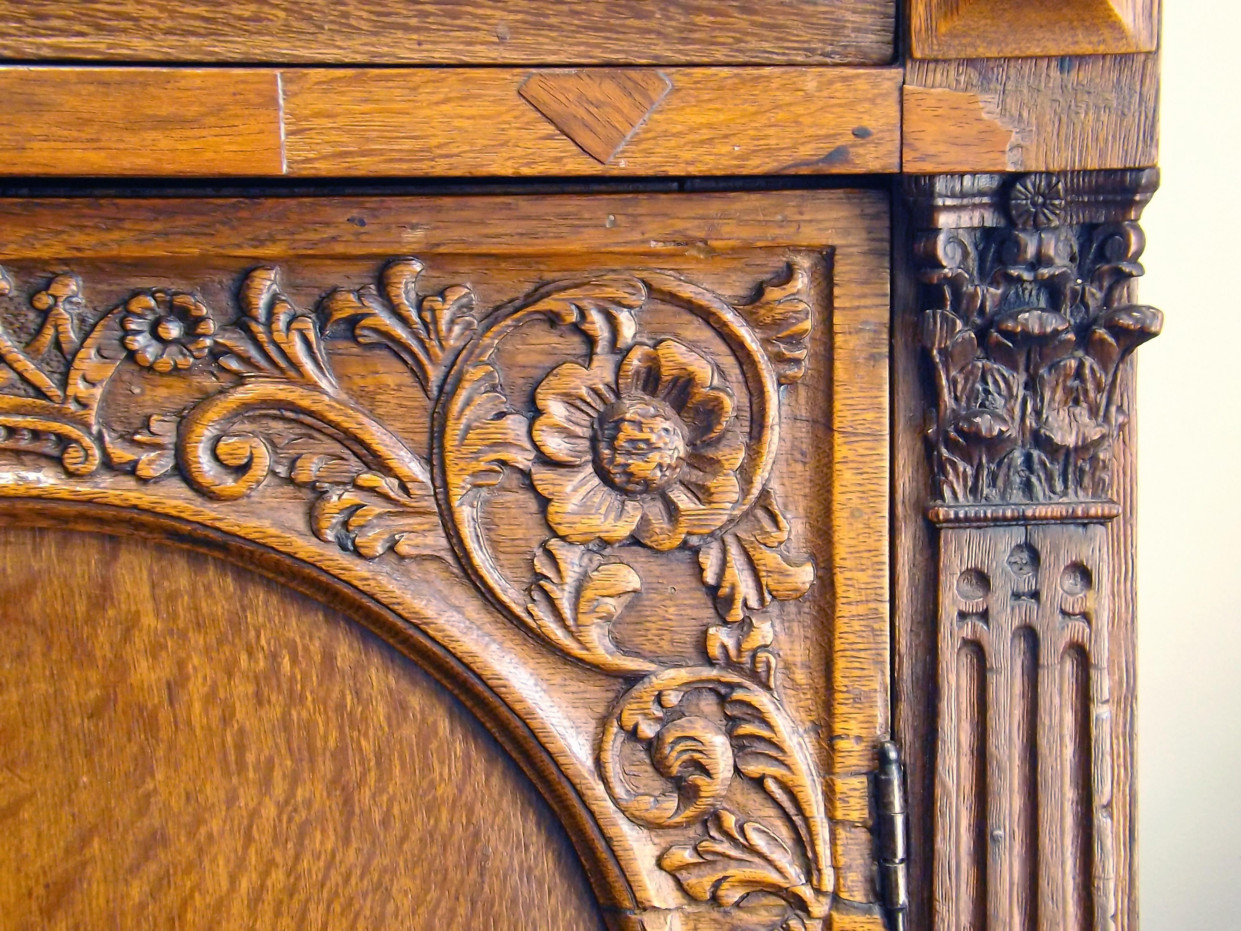 A beautifully carved two door cabinet, with one large exterior drawer. The two ornate doors open to reveal spacious shelving and two interior drawers. The flared top is 45 1/2 inches wide by 20 3/4 deep, while the body narrows to 41 inches wide by