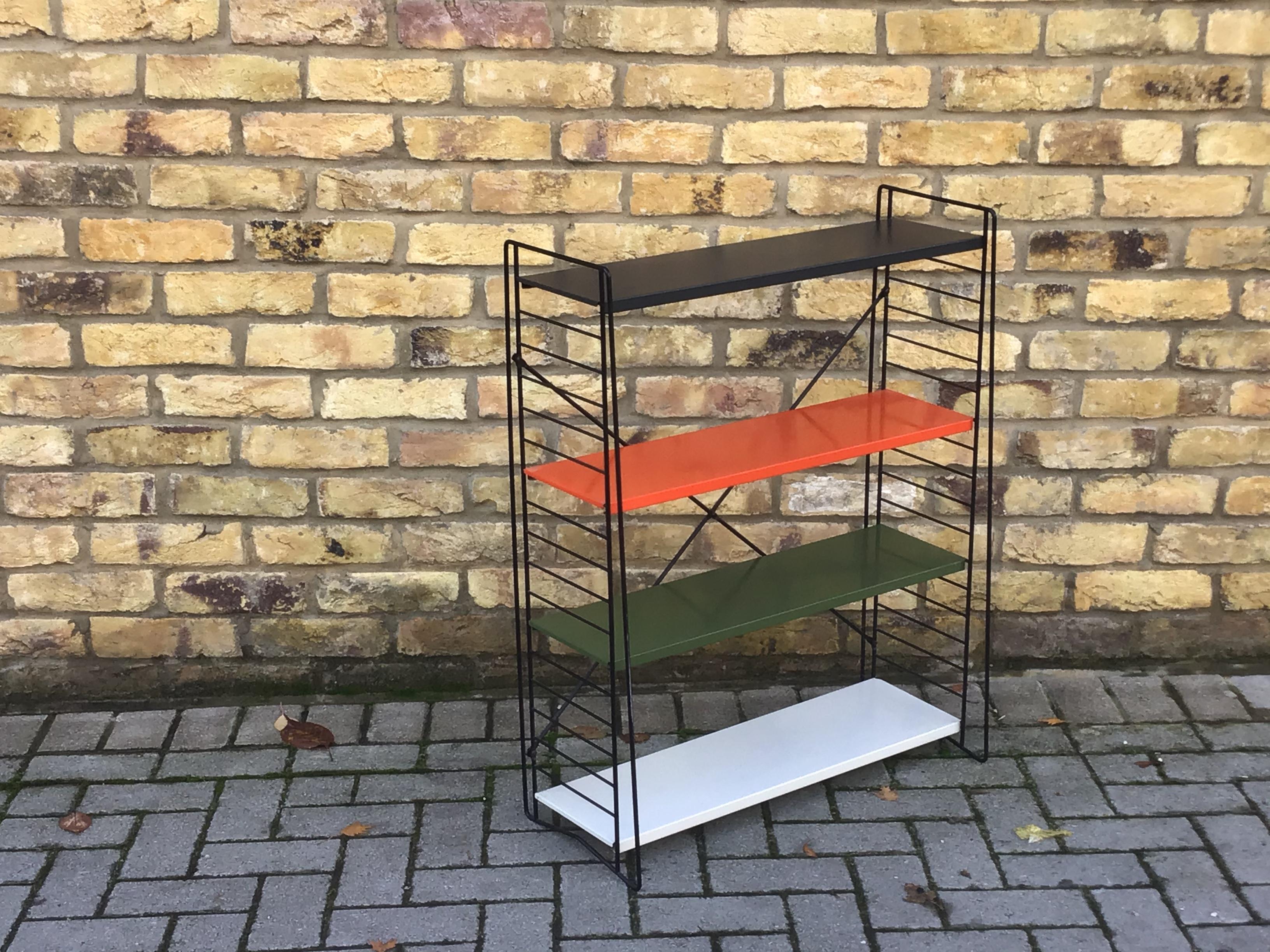 Tomado book shelving with white red and black metal enameled shelves on black enameled wire frame. Flexible and stylish with adjustable shelves. Can be disassembled and shipped flat, circa 1960s Dutch.