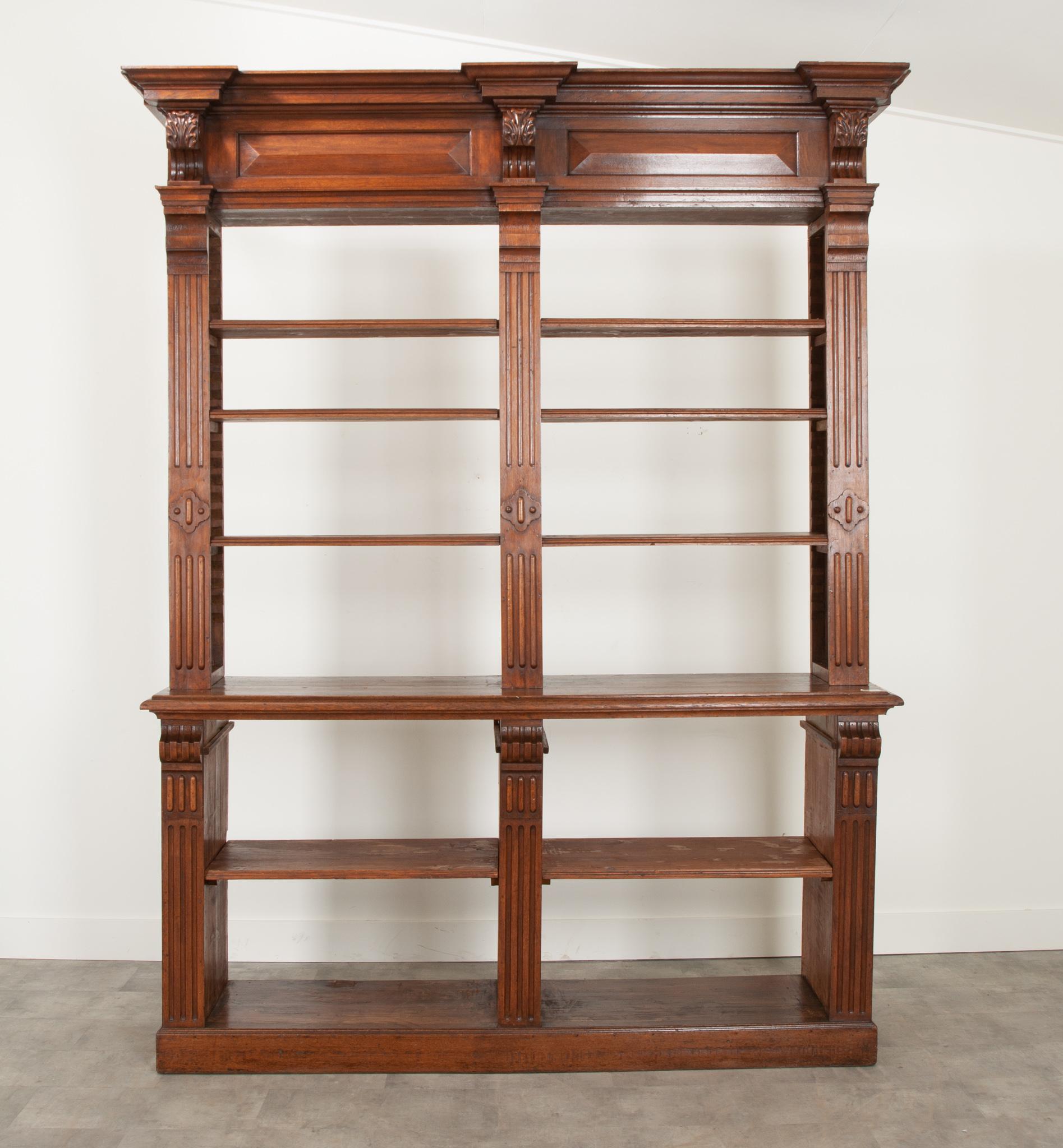 A massive Dutch apothecary display case from a pharmacy. A large cornice with gorgeous acanthus leaf carvings draws the eyes up. Three molded, adjustable shelves compose the top portion while the bottom single shelf is fixed. Fantastic reeding and