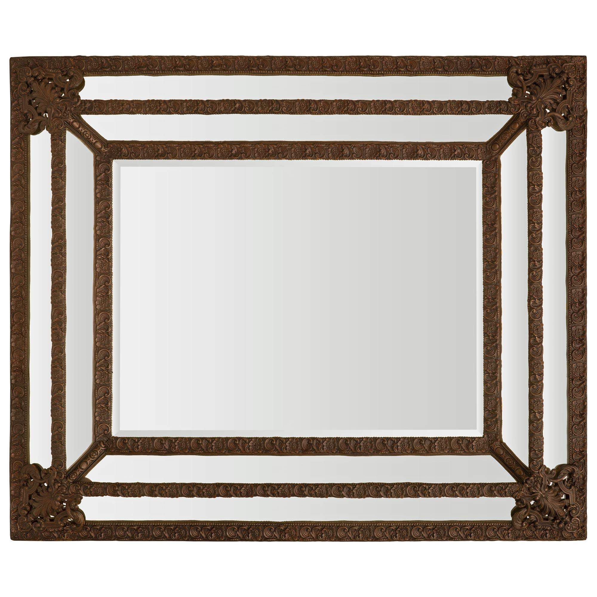 A most handsome Dutch 19th century Baroque st. patinated Pressed Metal double framed mirror. The mirror retains all original mirror plates, with the central beveled mirror framed within a finely mottled and beaded band with foliate and seashell