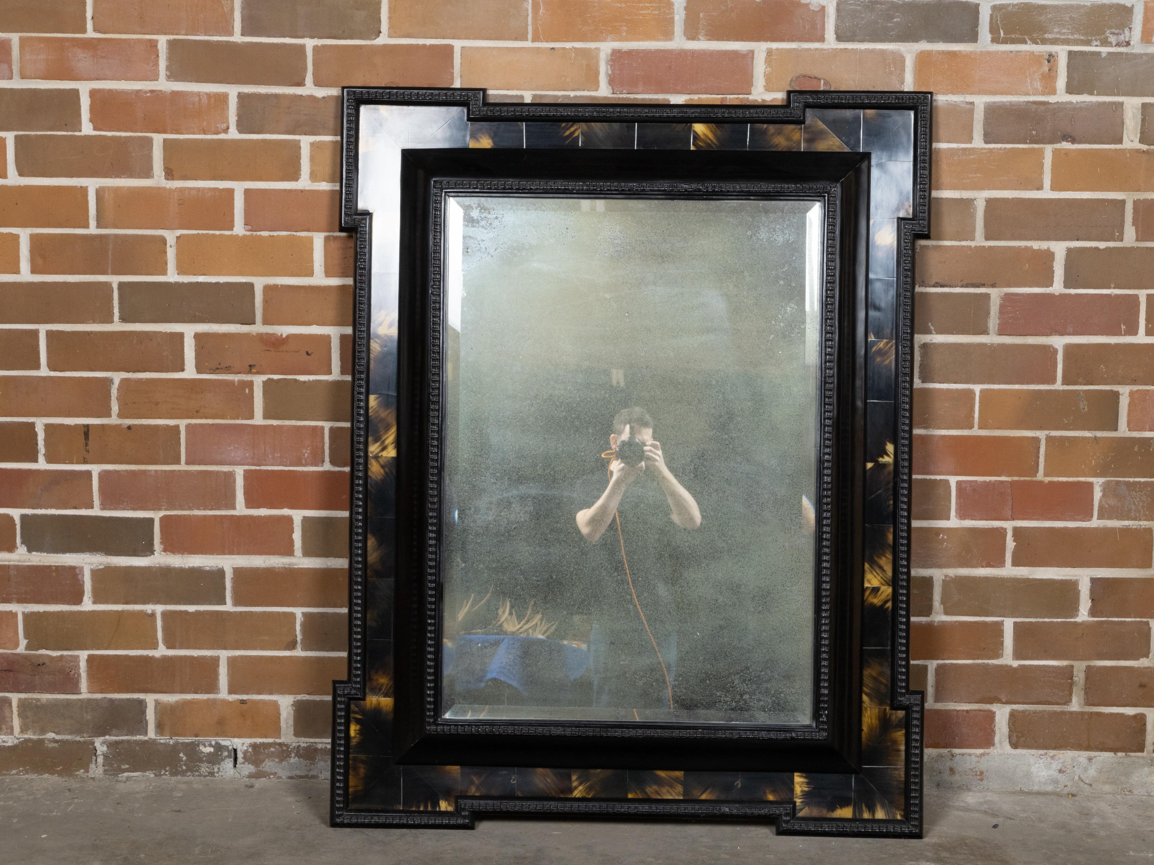 Miroir mural hollandais du XIXe siècle en faux noir de tortue avec des accents d'ambre, un cadre sculpté et des coins saillants. Ce miroir mural hollandais du XIXe siècle en faux noir de tortue rehausse la décoration de votre maison. Fabriqué avec