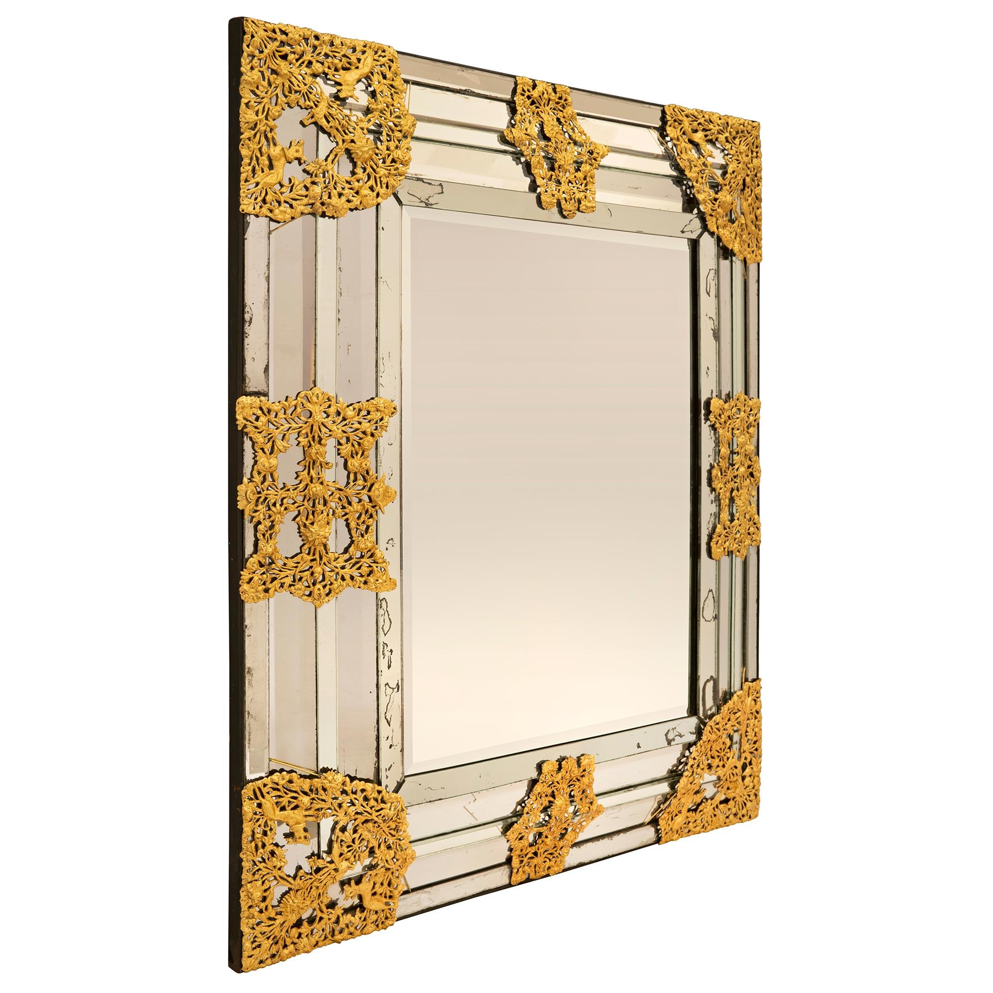 A stunning and extremely decorative Dutch 19th century gilt metal mirror. The exceptional and very unique mirror retains all of its original mirror plates throughout. The mirror plates along the sides are set at different angles creating a beautiful