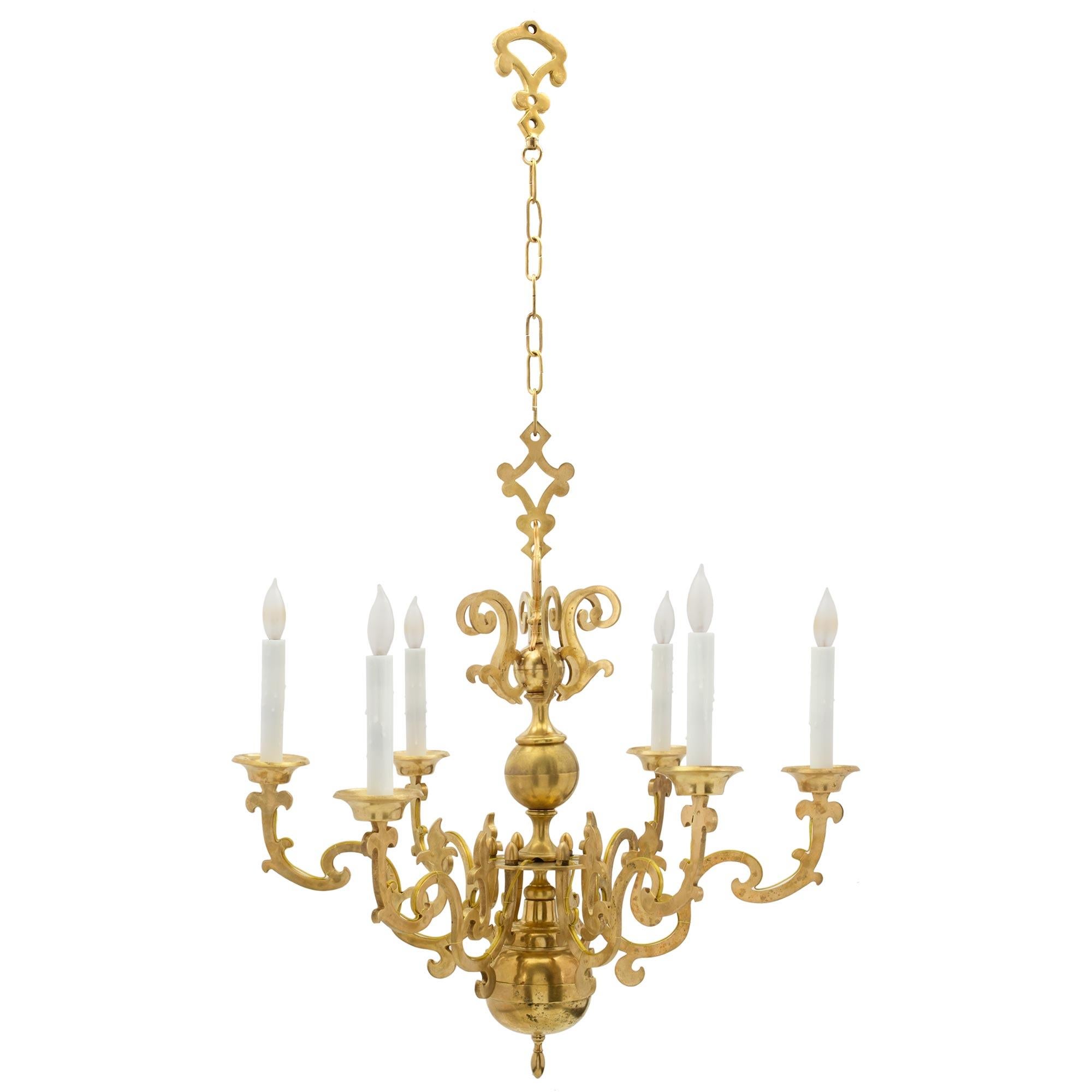 A beautiful Dutch 19th century ormolu six arm chandelier. The chandelier is centered by a fine finial below the circular central base. Each arm displays most decorative scrolled designs while the central fut displays a circular element with scrolled