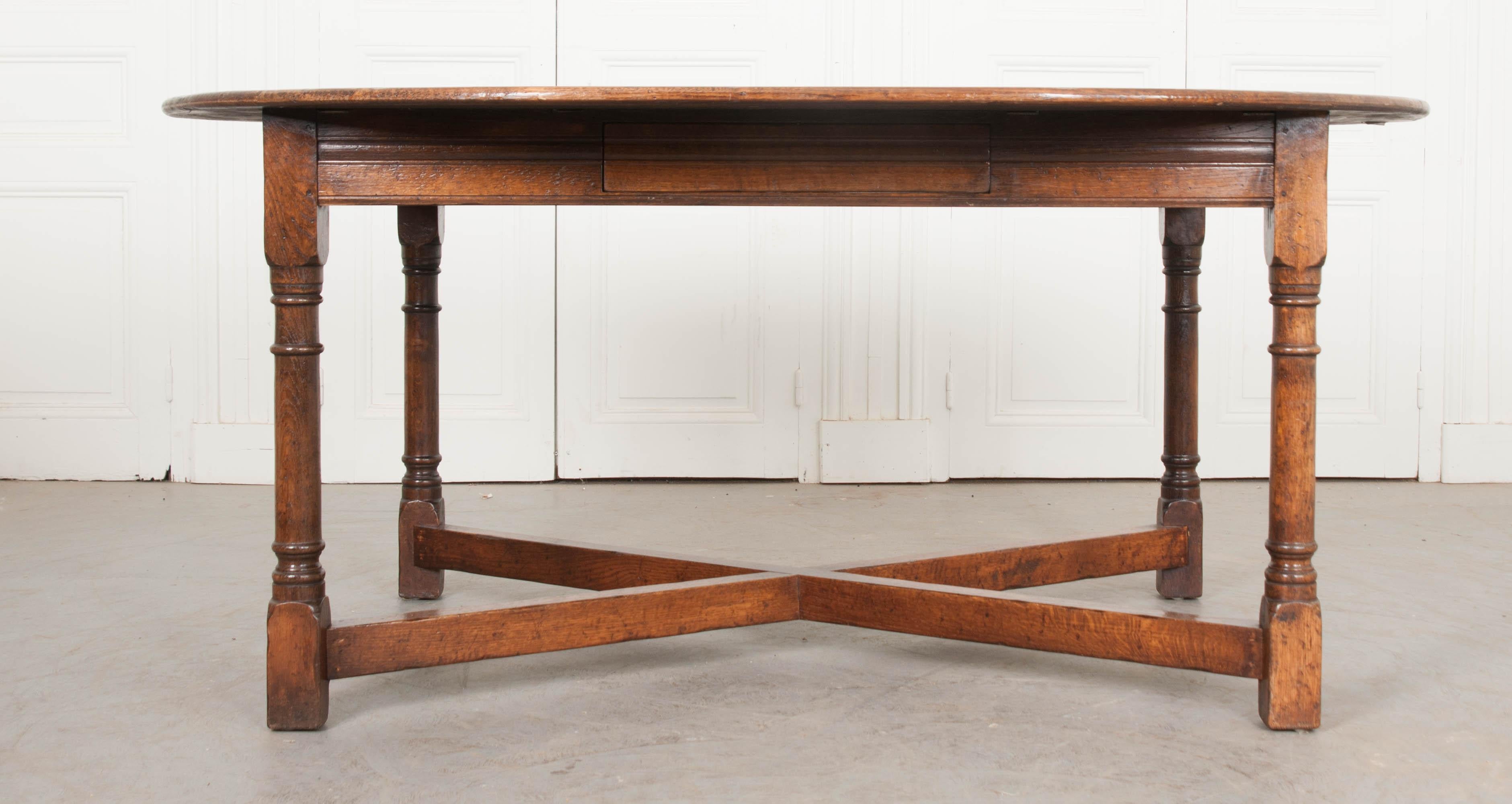 A uniquely styled oak dining table from The Netherlands, circa 1880. This exceptional table has an oval / capsule-shaped top that has a simple rounded edge. Its large size makes it ideal for having the family gather around for dinner, while its
