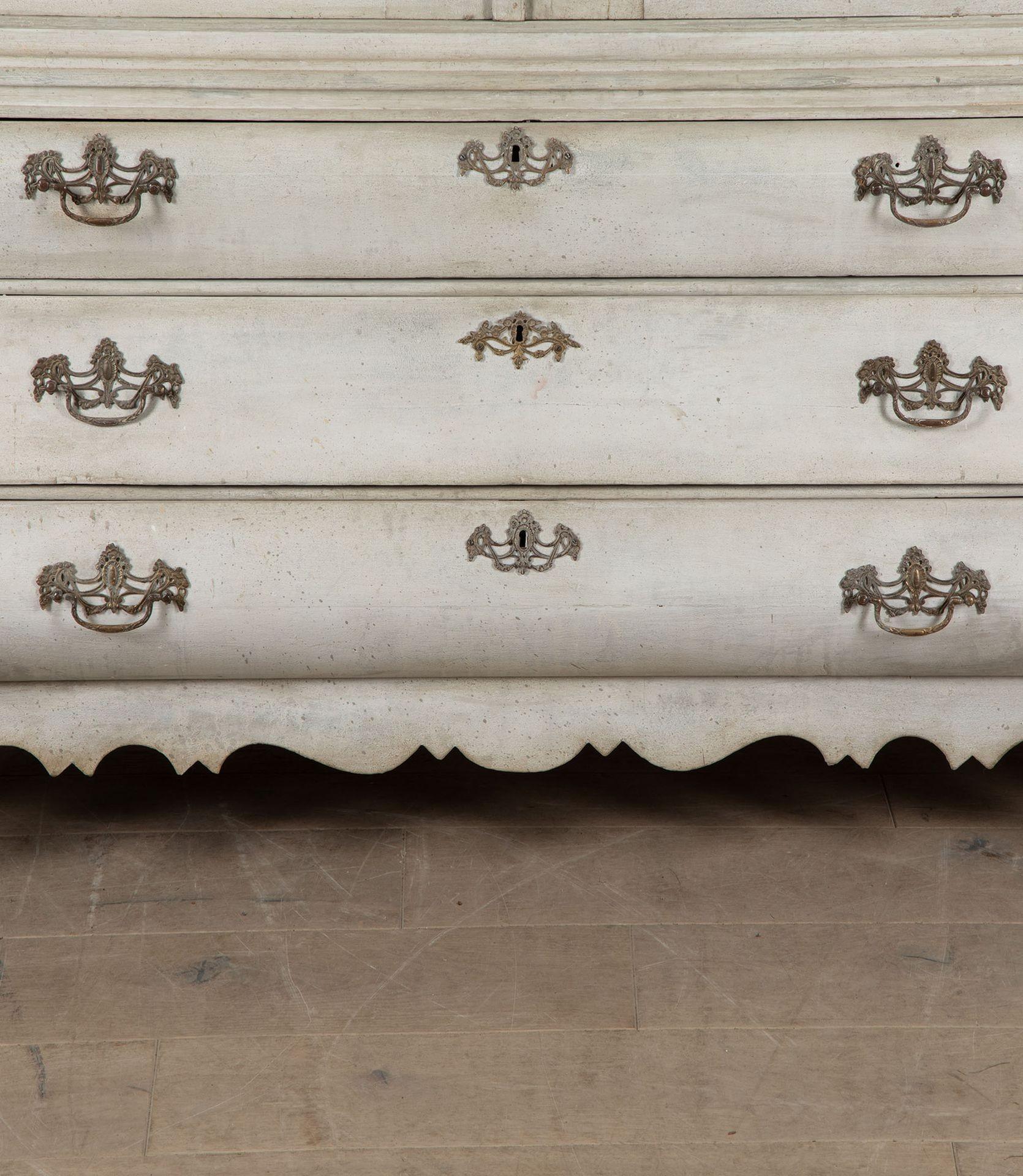 Impressively large Dutch 19th Century painted linen cupboard.
With a shelved two door top, over a bombe fronted chest of drawers.
The top has a vaulted roof with an applied and carved cartouche, over shaped panelled doors.
It is an architectural