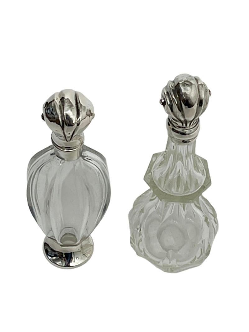 Dutch 19th century silver and crystal scent or perfume bottles

Dutch silver scent perfume bottles, early 19th century with tilt cap and stopper. 
The bottles are crystal cut, 1 of which has a silver base. 
The caps of both bottles are