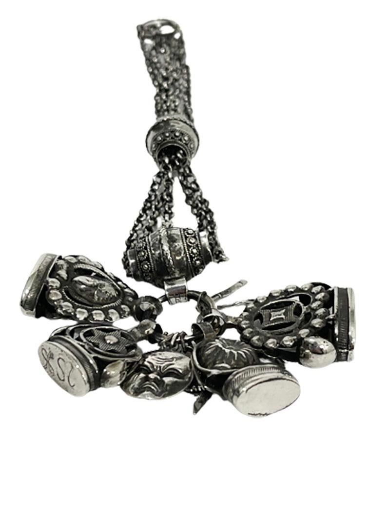 Dutch 19th century silver chatelaine with 4 cachets and charms

Silver chatelaine with 4 cachets and charms. 
The charms are a very small miniature knife and fork, a harlequin with movable arm and leg (part of the side is missing), a moon with a