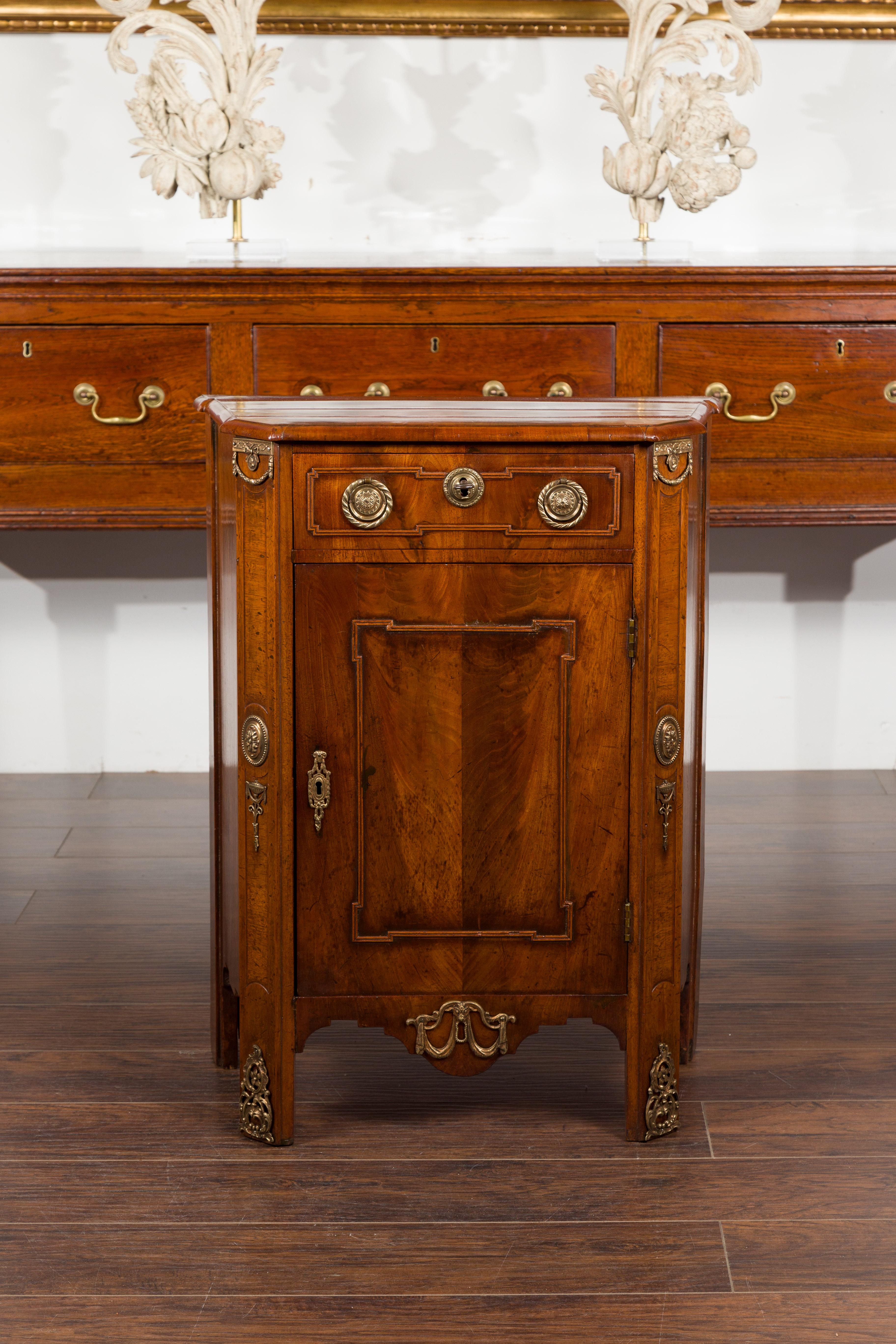 A petite Dutch walnut cabinet from the 19th century, with single drawer over door and bronze mounts. Created in the Netherlands during the 19th century, this walnut cabinet features a rectangular tapering veneered top sitting above a single drawer