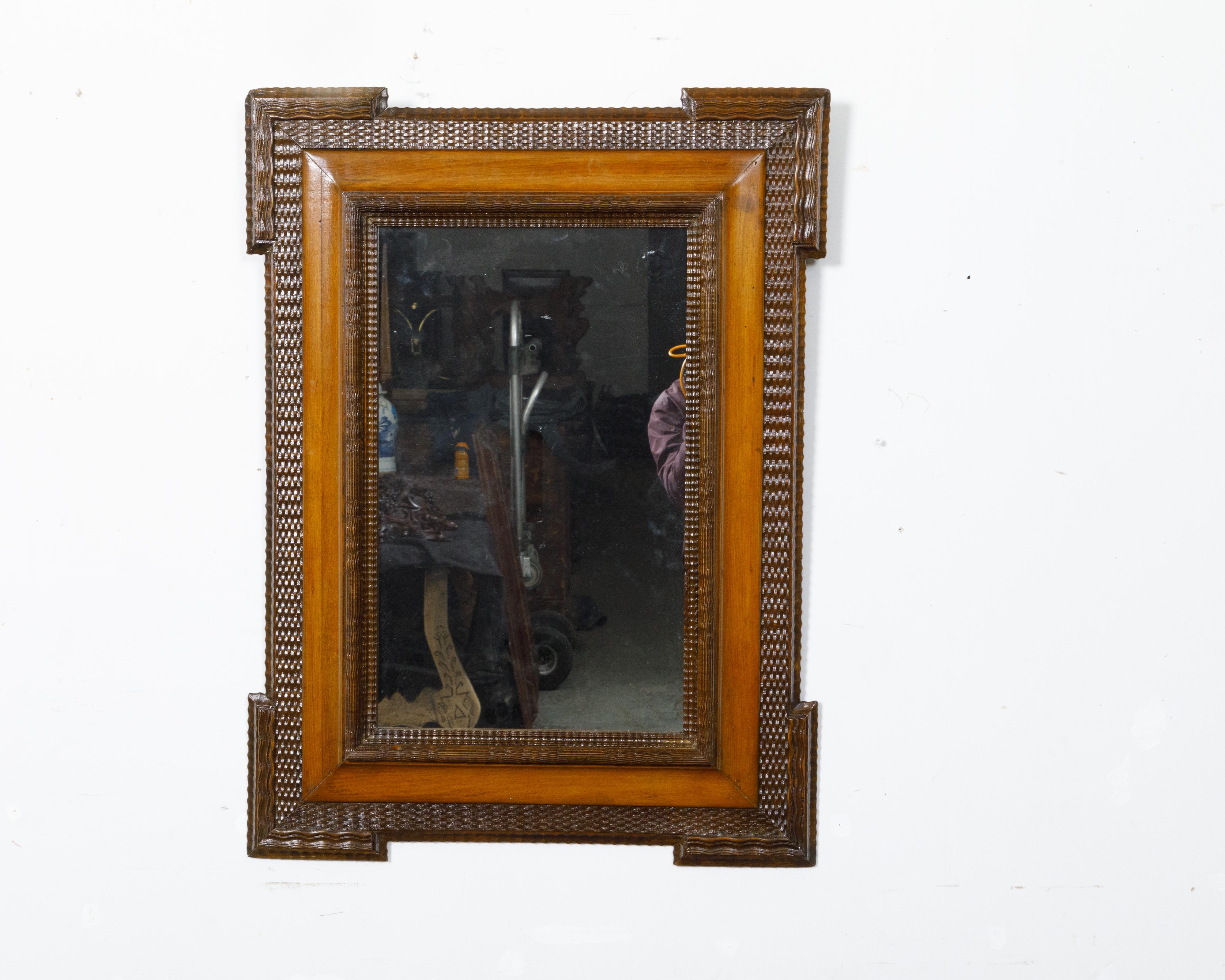 Miroir mural hollandais en noyer du XIXe siècle, avec décor sculpté à la main, angles saillants et patine brune. Cet exquis miroir mural en noyer hollandais du XIXe siècle capture l'essence de l'élégance intemporelle avec son décor sculpté à la
