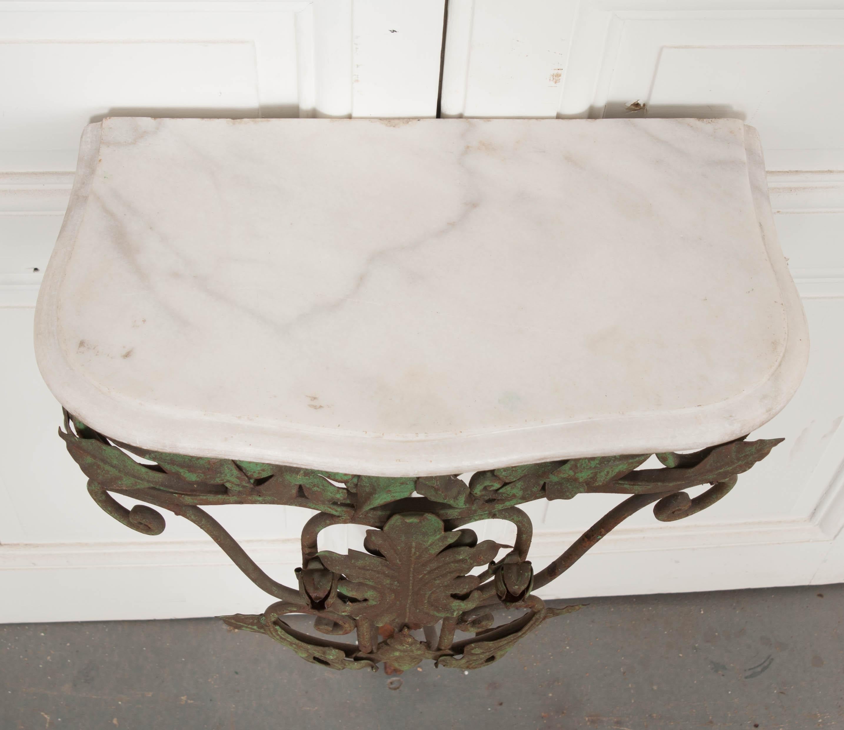 This lovely verdigris-painted iron and white marble-top wall-mounted console is from the Netherlands, circa 1920s, and features floral and foliate decor. The diminutive size makes it perfect for smaller interiors.