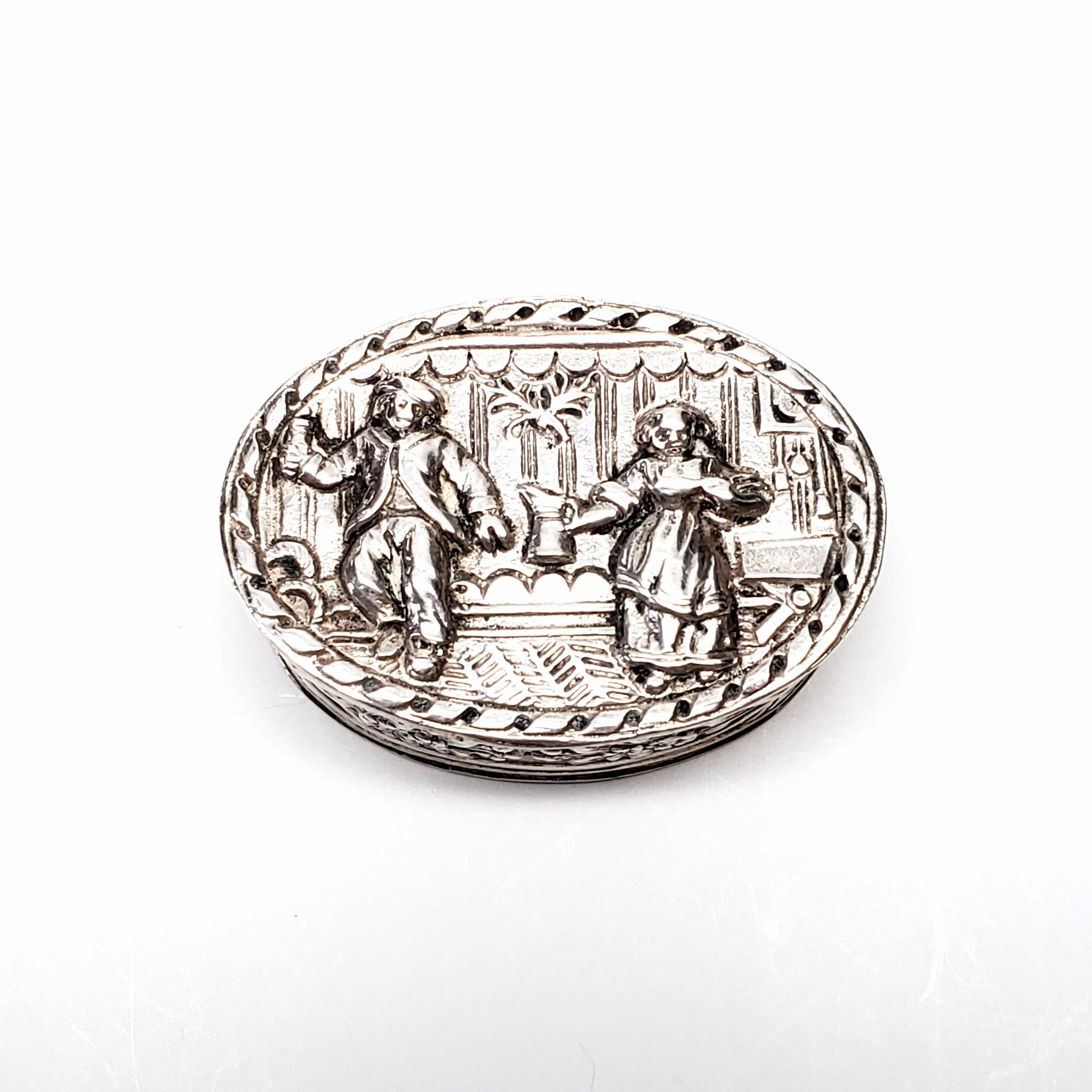 Antique Dutch 800 silver hinged oval pill box.

This is a beautiful example of repousse silver box. The lid depicts a tavern scene of dancing and drinking. Ornate floral design all around the sides.

Measures 1 1/8