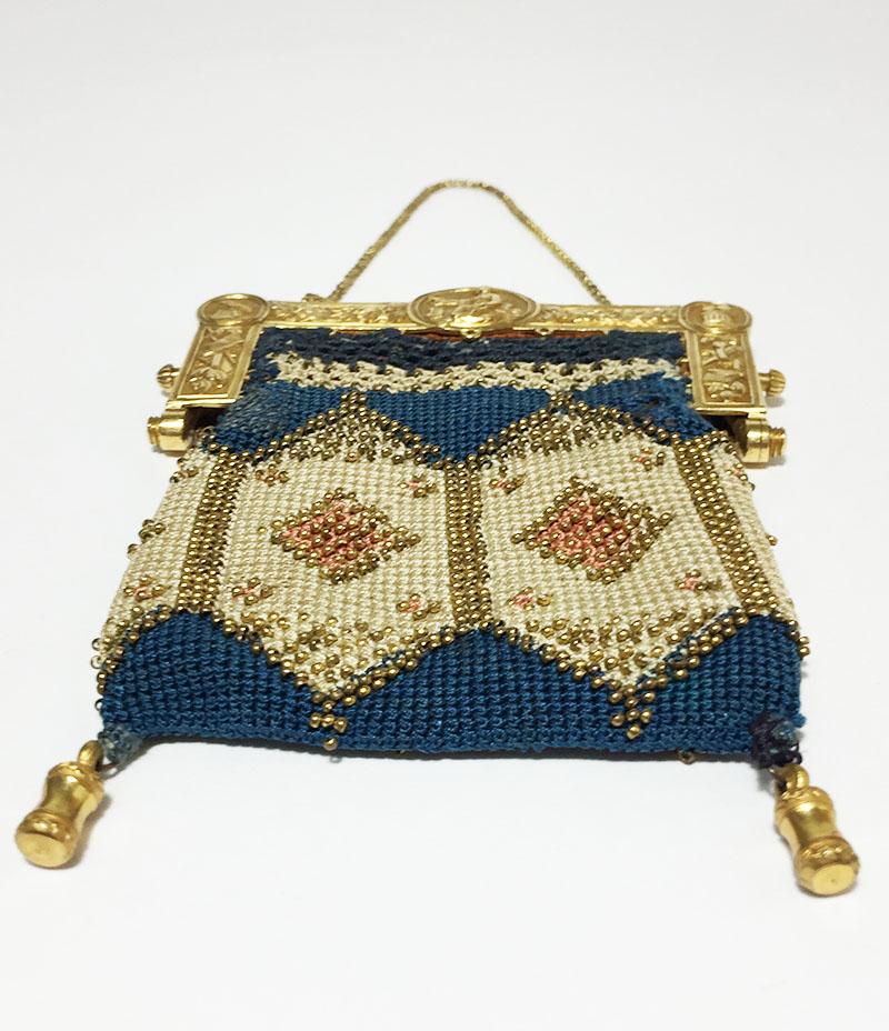 Dutch embroidered purse with golden purse mount, Amsterdam 1812

A golden purse mount with very small golden beads on a embroidered sac
The purse mount has a scene of a fisherwoman with an anchor in her left hand and a bird on her right, waiting on