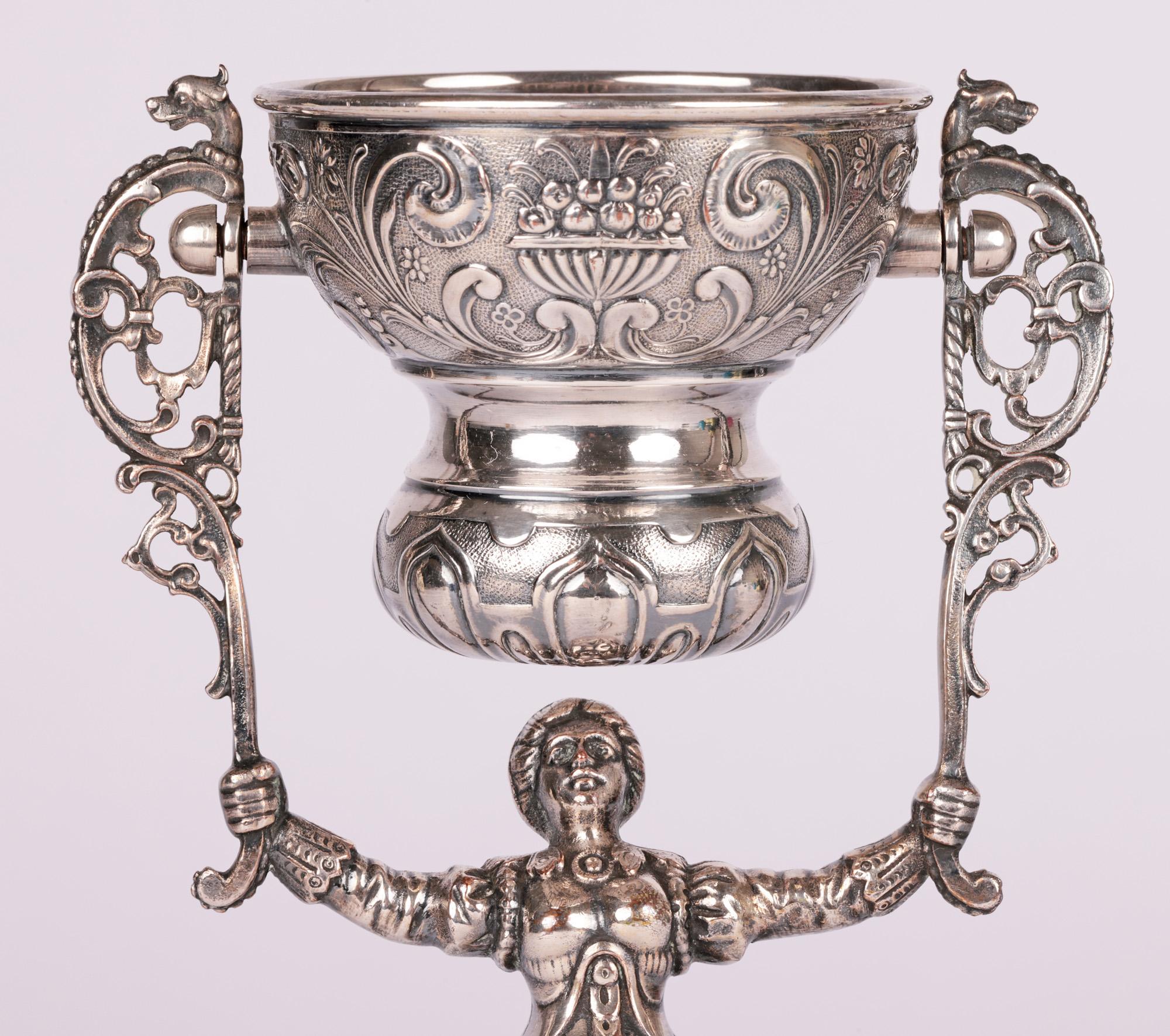 A superb quality Dutch antique silver-plated marriage wager cup dating from the 19th century. The cup is formed as a lady with a bell shaped body formed as a long skirt heavily embossed with scroll patterning with bird heads, flowers and leaves. The
