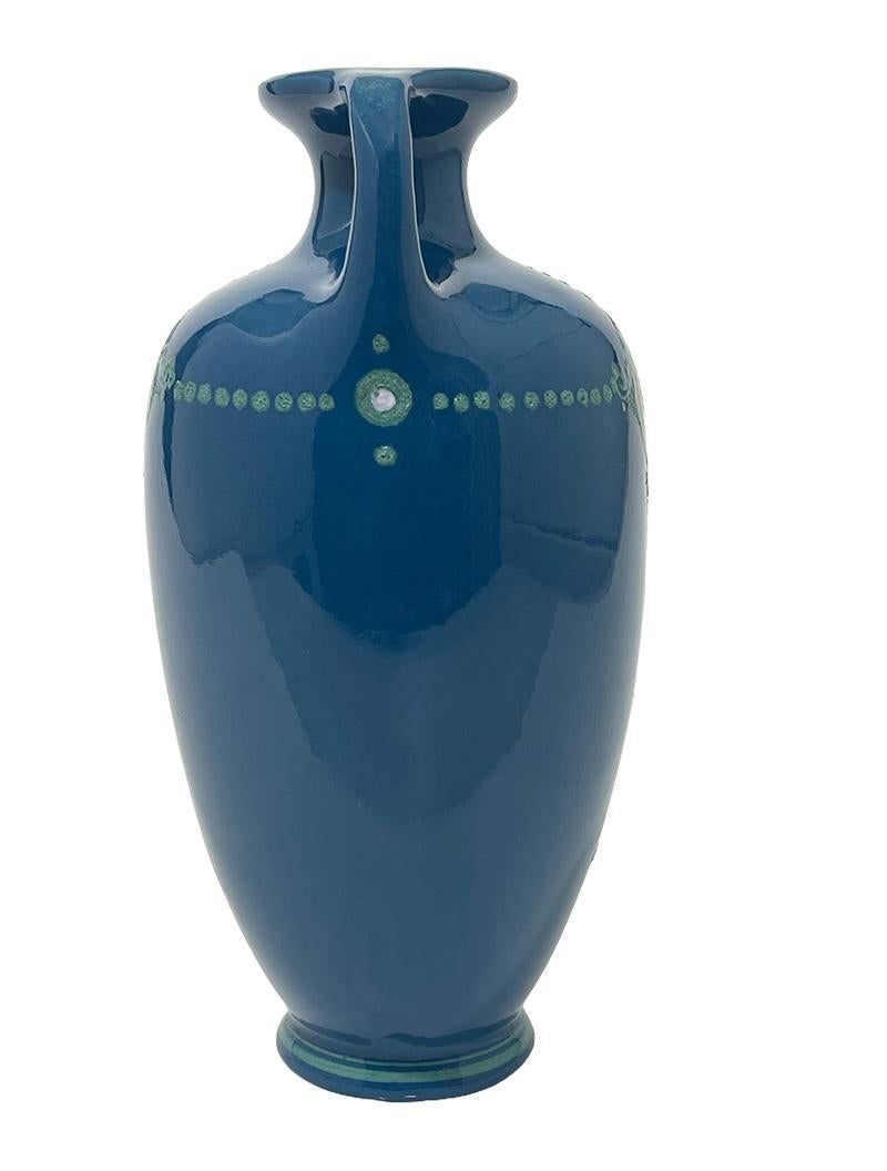 Dutch Arnhemsche Fayencefabriek, N.V. earthenware vase, 1910-1915

Dutch Arnhemsche Fayencefabriek earthenware vase with 2 handles, (model number 42), blue glaze with polychrome linear floral decoration, design by Klaas Vet, executed by Arnhemsche