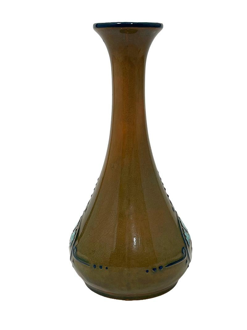 Dutch Arnhemsche Fayencefabriek, N.V. earthenware vase, ca.  1910

Dutch Arnhemsche Fayencefabriek earthenware vase, (model number 1008), brown glaze with  linear floral decoration in relief, design by Klaas Vet, executed by Arnhemsche