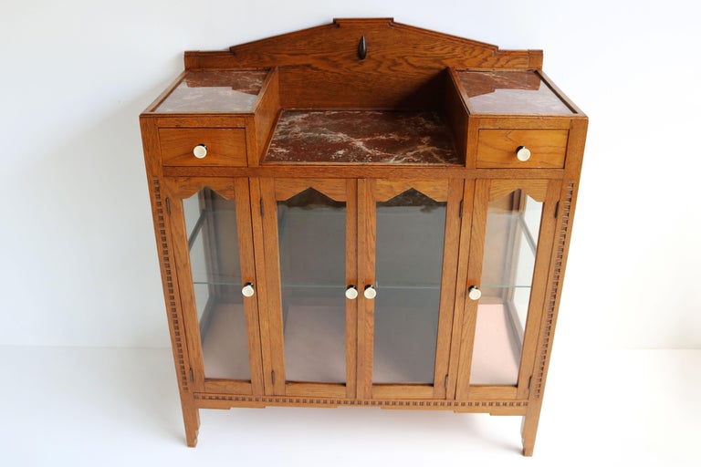Exquisite & Luxurious! This Dutch antique Art Deco Tea cabinet / display cabinet from 1920 in Amsterdam School design style. 
Marvelous Amsterdam School geometric shapes & stair shaped details. all made from solid European Oak. 
Three gorgeous faux