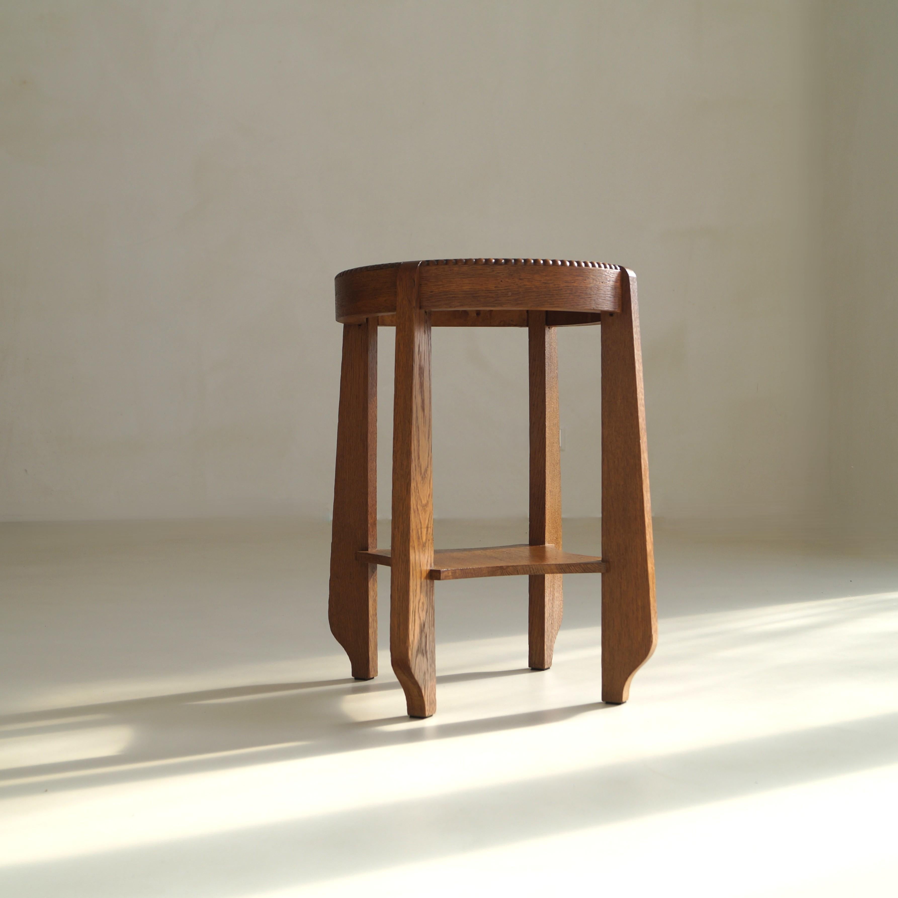 A modestly sized elegant occasional table or side table in oak featuring a beautiful beaded edge of carved wooden ‘pearls’ around the tabletop.  A very nice accent piece in interesting, eclectic interiors. It is a very well made and sturdy little