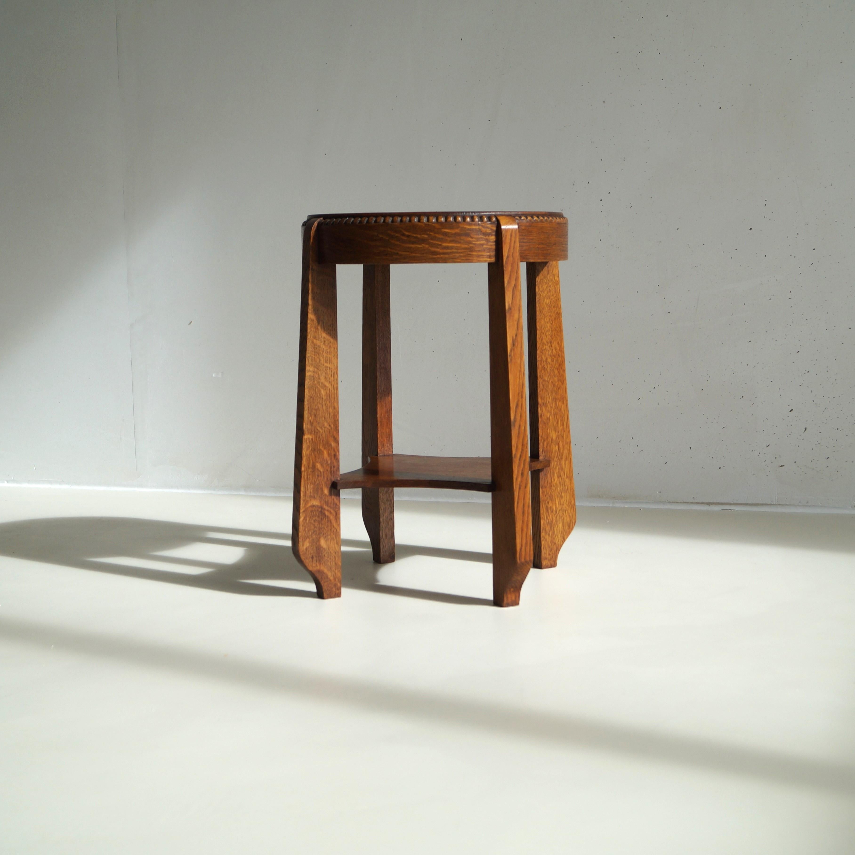 A modestly sized elegant occasional table or side table in oak and a decorative rim of wooden 'pearls' around the tabletop.  A very nice accent piece in interesting, eclectic interiors. It is a very well made and sturdy little table. It has very