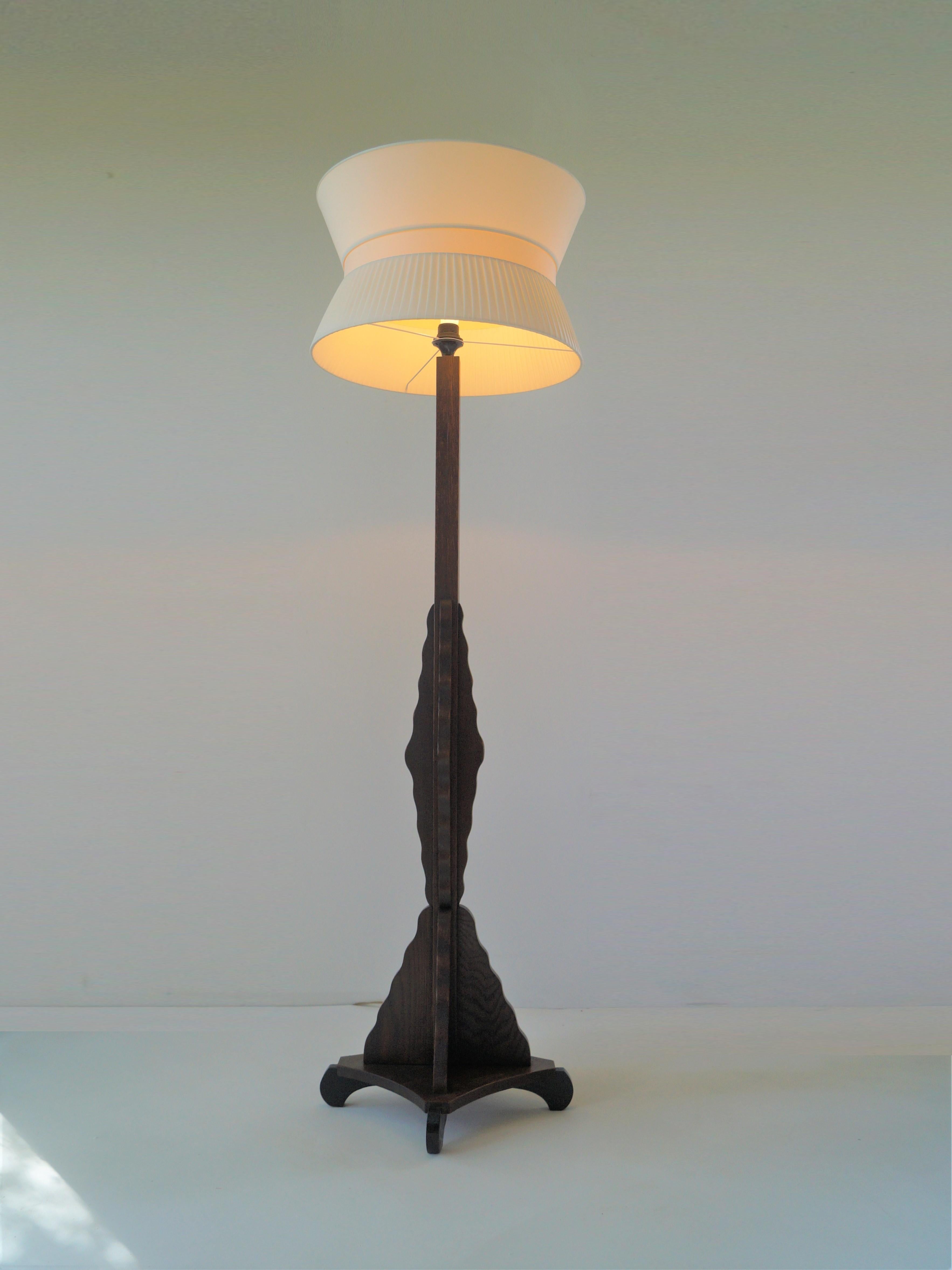 An elegant Dutch Art Deco 1920s floorlamp, Amsterdamse School (Amsterdam School). Made from solid woodcarved oak this piece has an organic, sculptural  design and blackened leg ends on the four tapered sides. 
This piece combines very well with