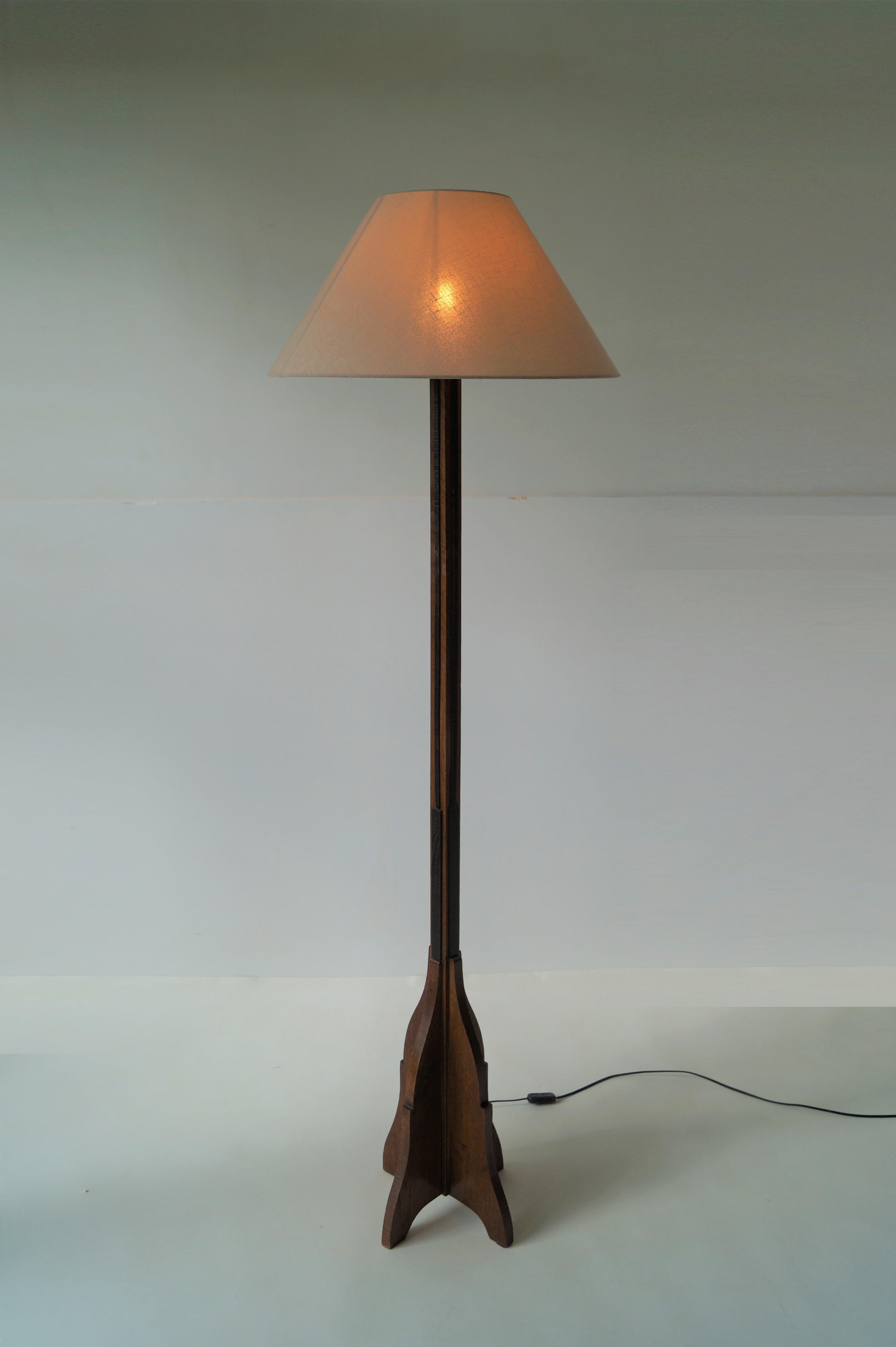 An elegant Dutch Art Deco 1920s floorlamp, Amsterdamse School (Amsterdam School). Made from solid woodcarved oak, decorated with slats of black stained oak, this piece has an elegant appearance. 
The lamp combines very well with other Amsterdam