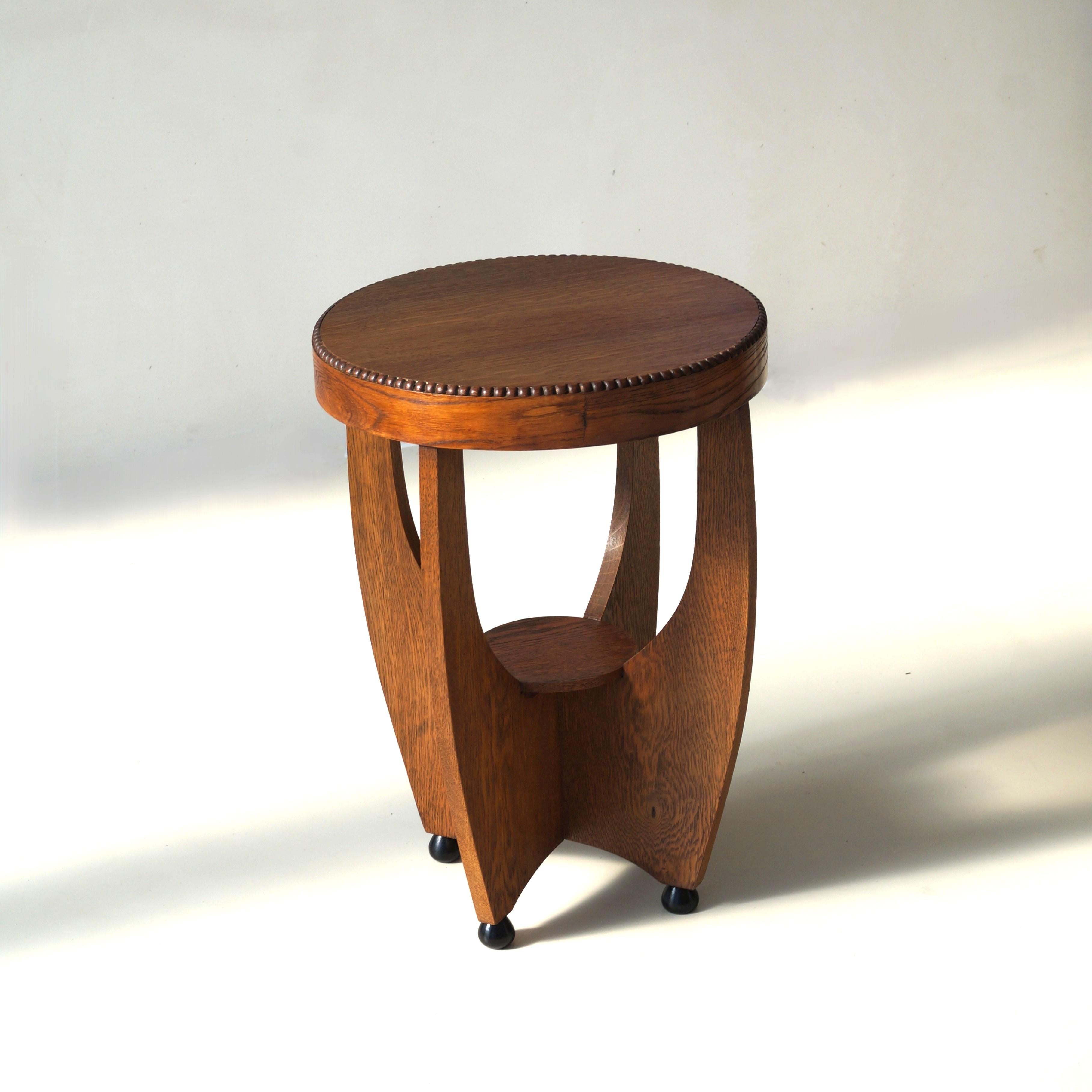 A Dutch Art Deco nicely sized and very elegant occasional table or side table. The table has a sculptural design and the feet are black and slighly conical in shape. This table is suitable as an accent piece in any eclectic interior, but also in
