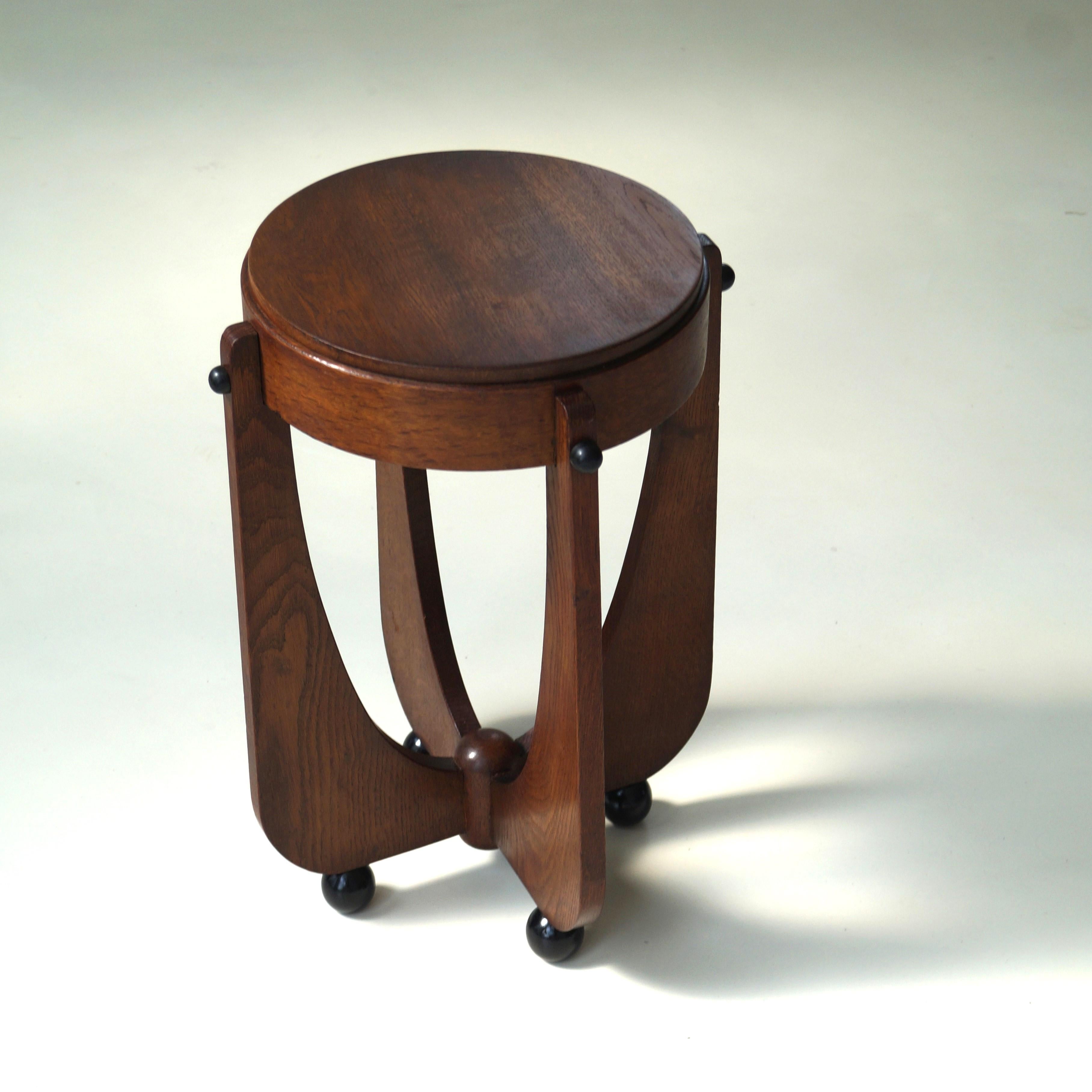 A Dutch Art Deco modestly sized elegant occasional table or side table in oak and black laquered balls for feet. An very nice accent piece in interesting, eclectic interiors. It is a very well made and sturdy little table with marvellous details. It