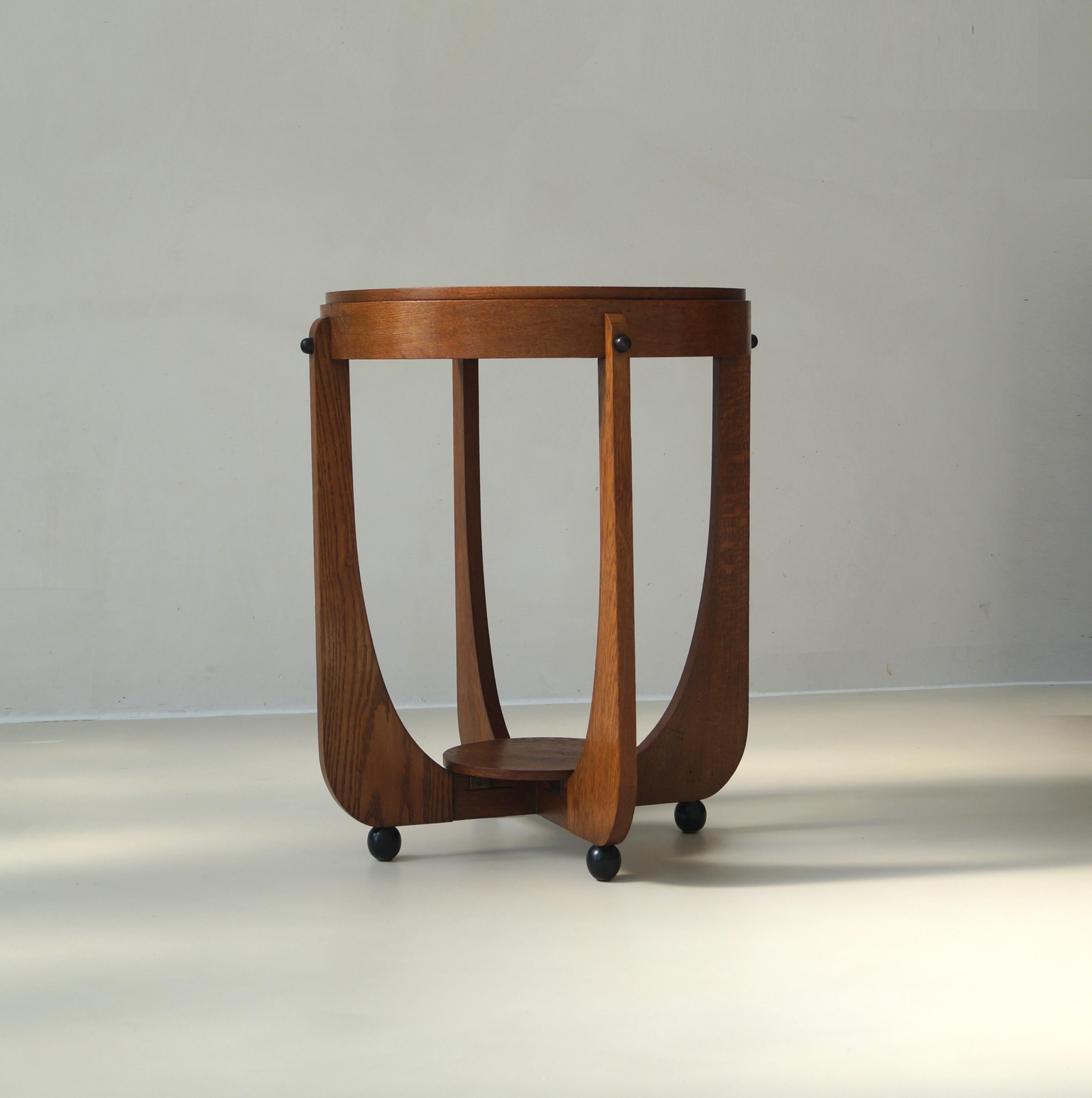 A Dutch Art Deco good sized elegant occasional table or side table in oak and black laquered balls for feet. An very nice accent piece in interesting, eclectic interiors. It is a well made table with marvellous details. It has small signs of age and