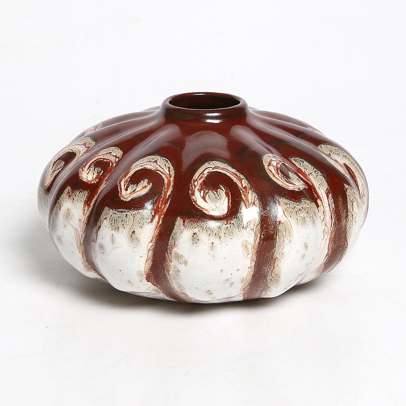 A Dutch Art Deco ceramic vase with swirl pattern in deep red and white glazes. Made by Gouda, Plateelbakkerij Zuid-Holland. Made circa1930.

Measures: Diameter 7