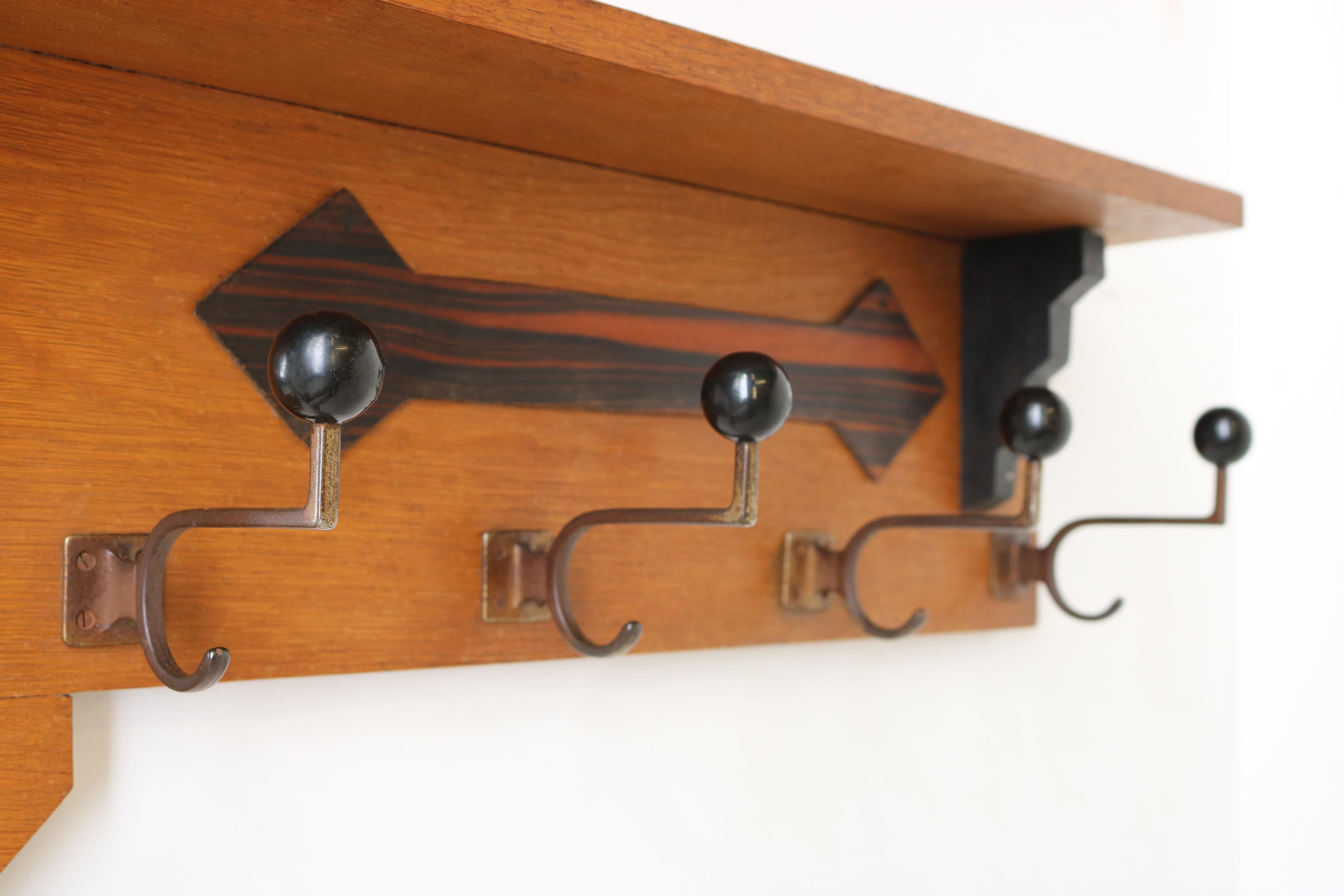 Marvelous Dutch Art Deco Amsterdam school coat / hat rack with beveled mirror.
Made from European Oak & black accents and Macassar decorated detail. Exquisite Art Deco design with typical Amsterdam School elements. 
Asymmetrical stair shape going