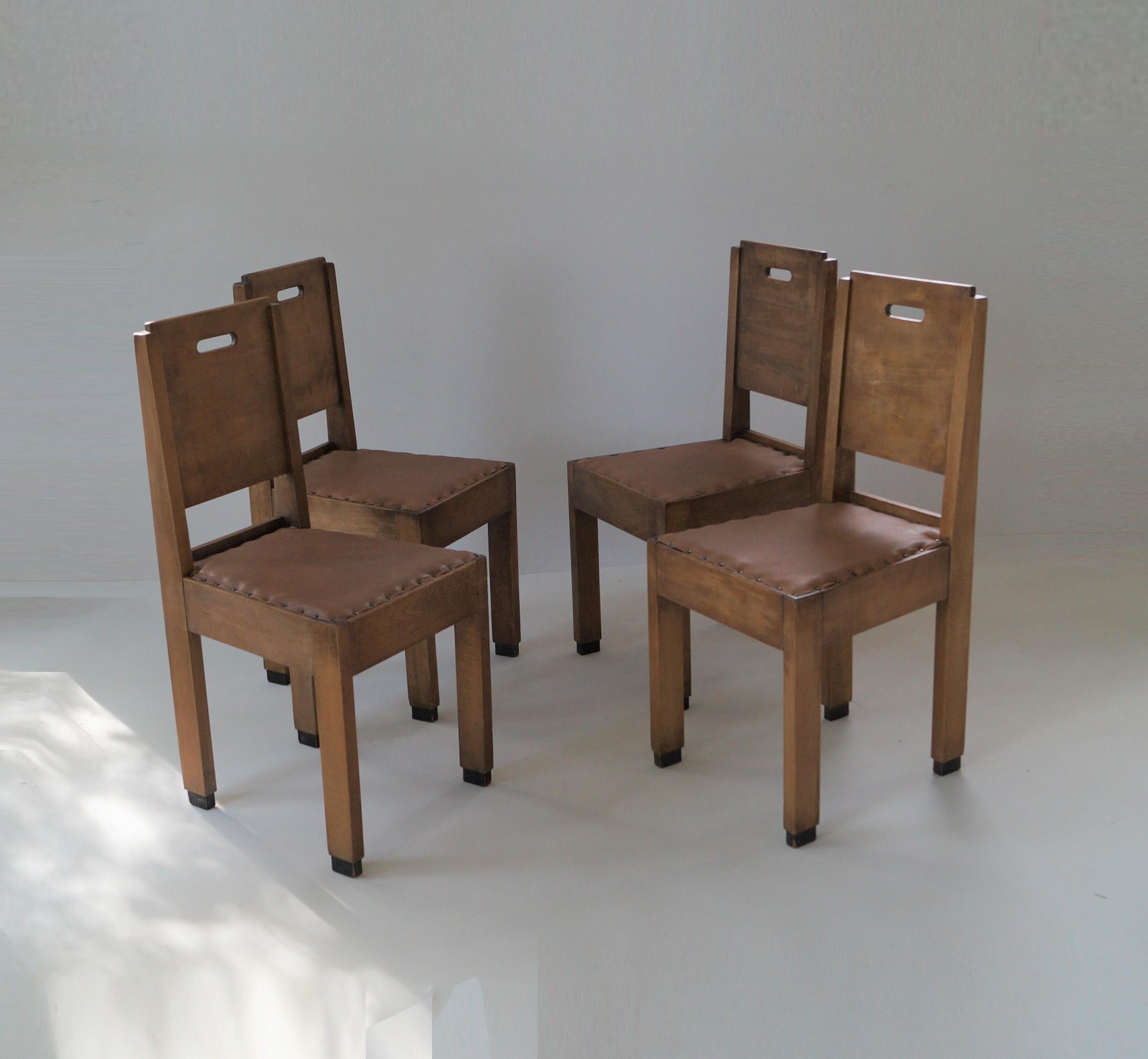 Unique set of four early (around 1910-1920) Haagse School dining chairs with De Stijl influences. Very austere and functional design with clean lines and oval shaped recesses that operate as handles. Great in an out of the box or minimalist interior
