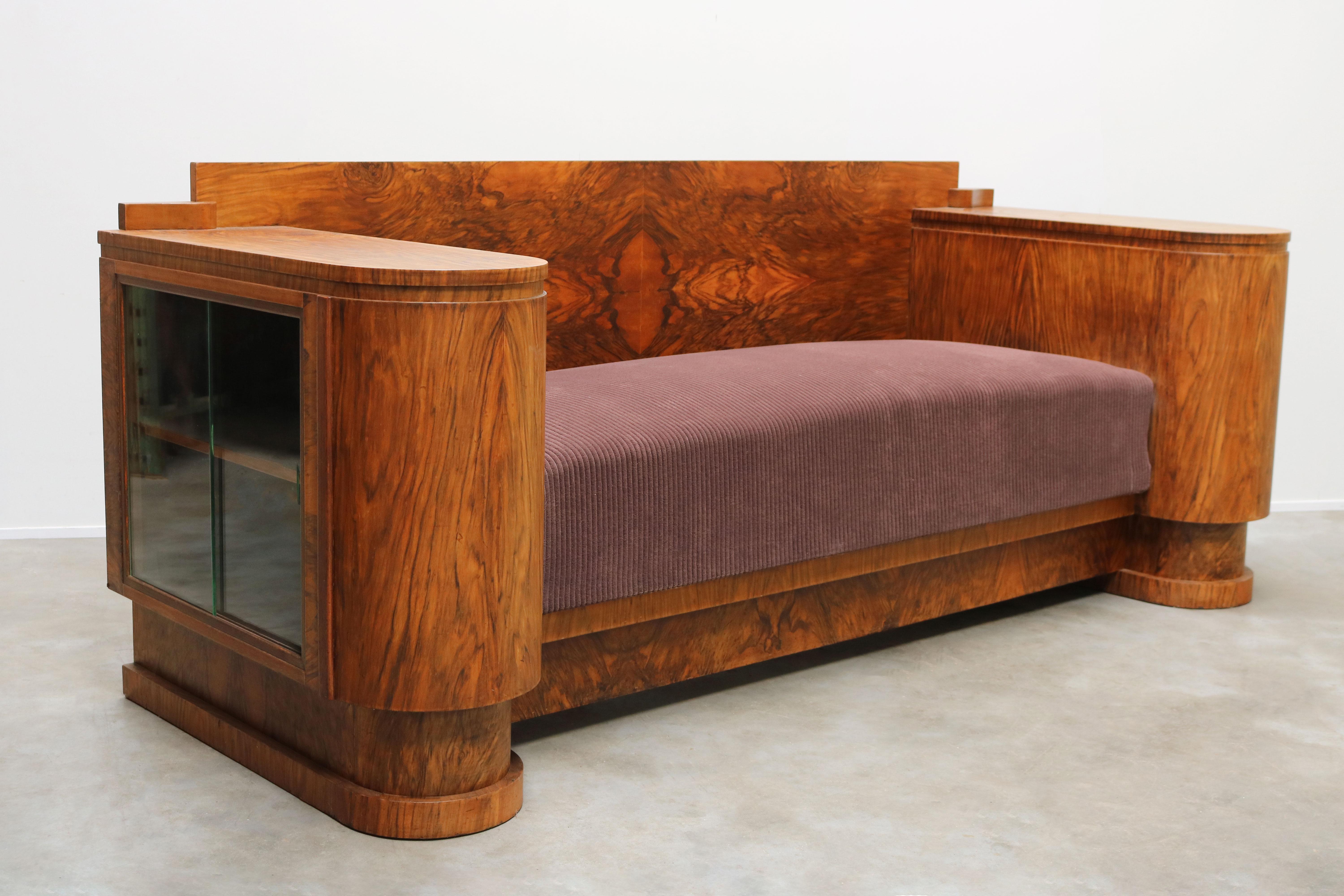 Marvelous high end design Dutch Art Deco sofa designed & produced by Pander 1930 in Burl Walnut. 
Exquisite Art Deco design lines & both sides of the sofa have display cabinets perfect for storing Books / Drinks. 
The Burl Walnut looks simply