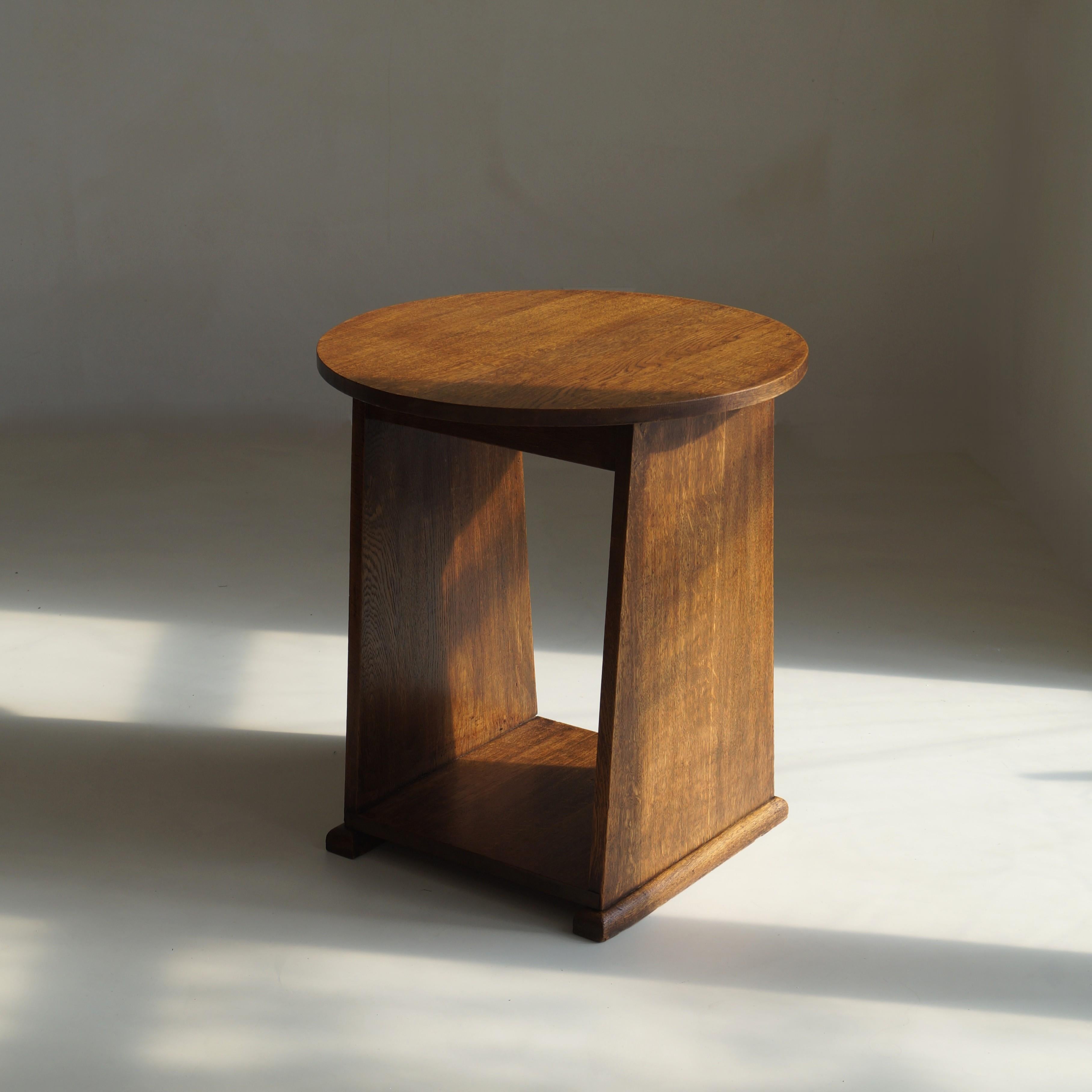 Ein niederländischer modernistischer Tisch aus massiver Eiche aus den 1920er Jahren mit runder Platte, die sich zum Sockel hin verjüngt und auf einem Schlittensockel steht. Ein einfaches, aber ungewöhnliches Design, das durch seine Geometrie und