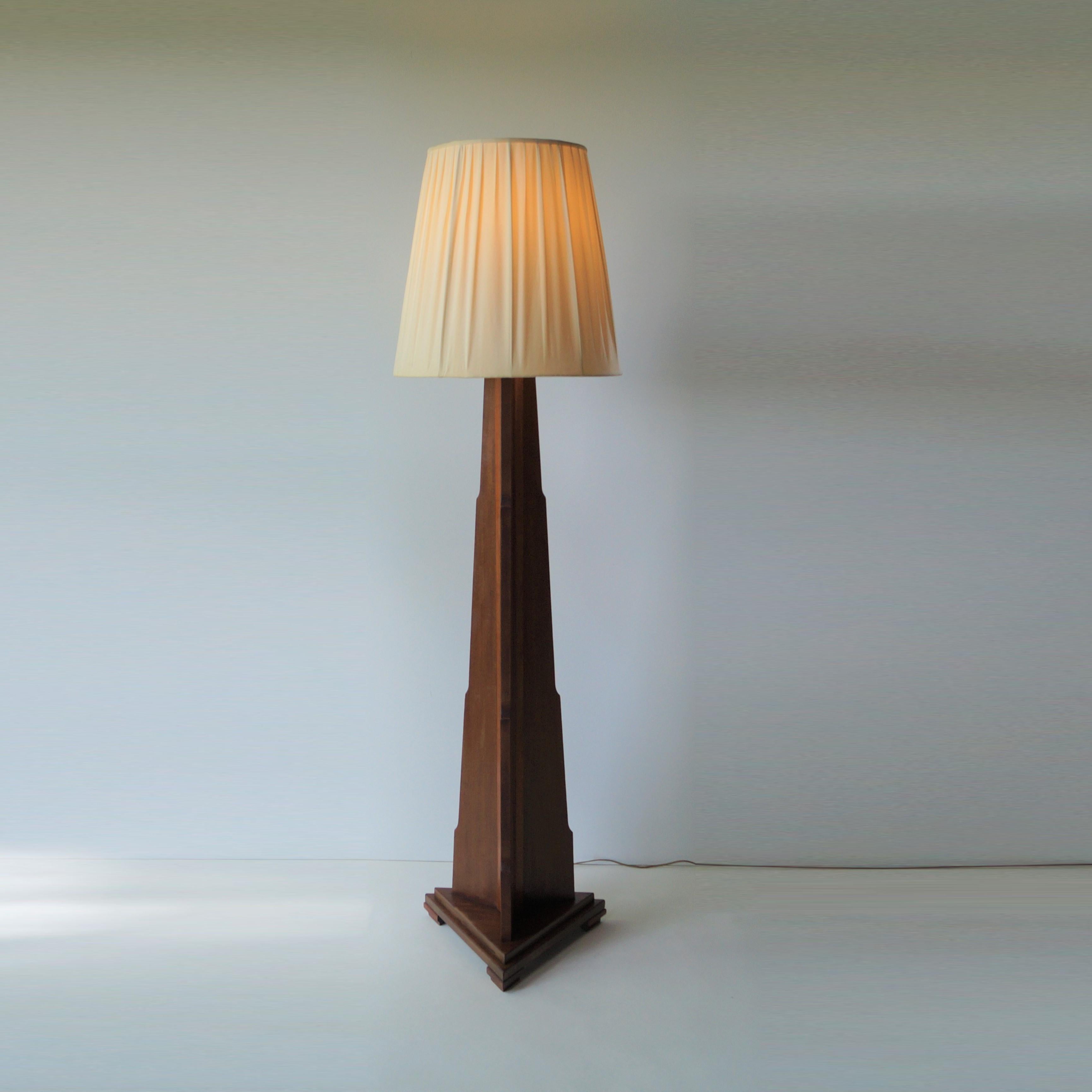 A remarkably large Dutch 1920s - 1930s floorlamp with a modernist design, with some characteristics of the Amsterdamse/Haagse School. In solid mahogany with a triangular base and woodcarved stepped design on the three sides. Made from mahogany.