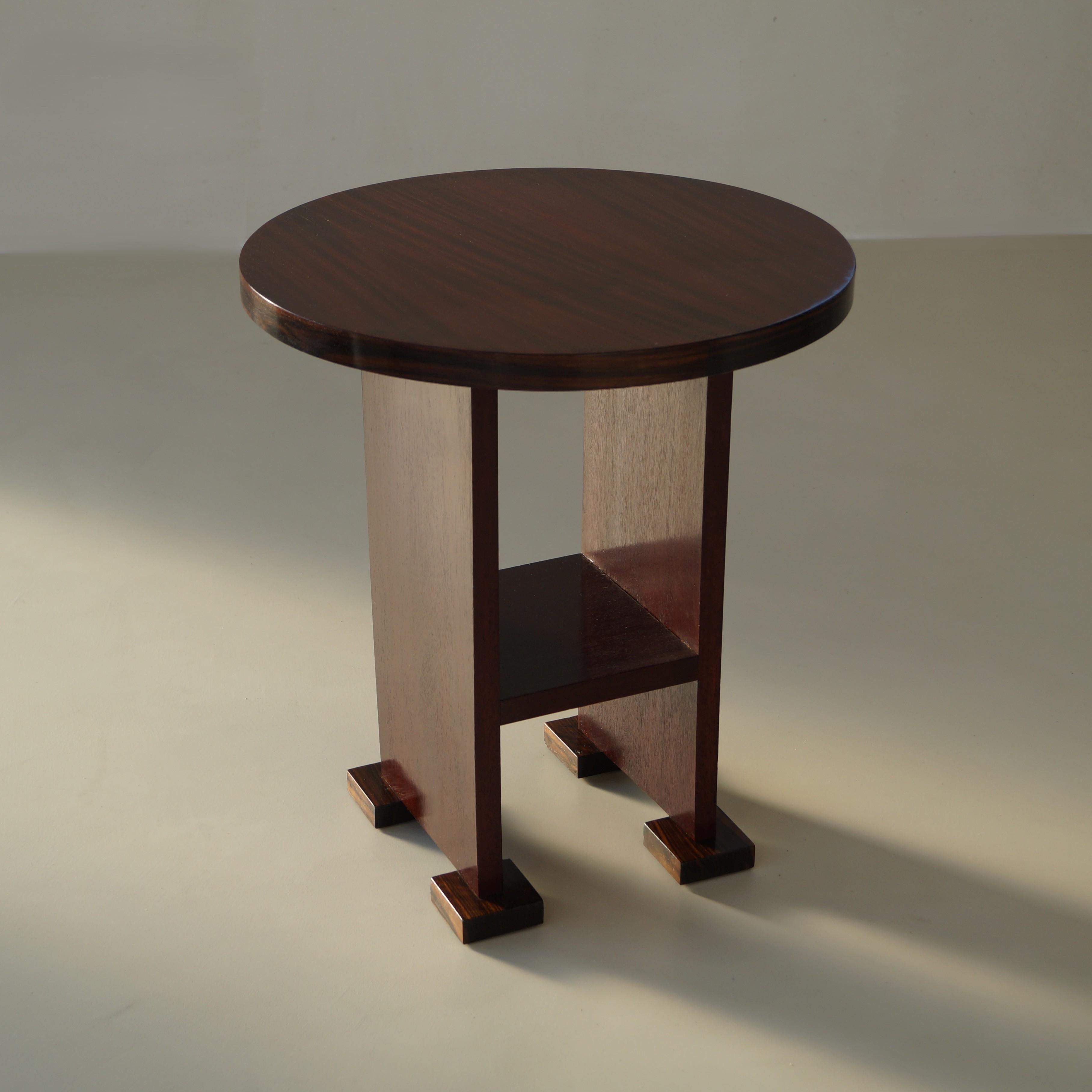 A rare 1920s Dutch Art Deco side table with a stylish modernist design, which makes it a nice accent piece in a stylish interior. Made from stained walnut, macassar ebony feet and macassar around the tabletop.

The table is in very good
