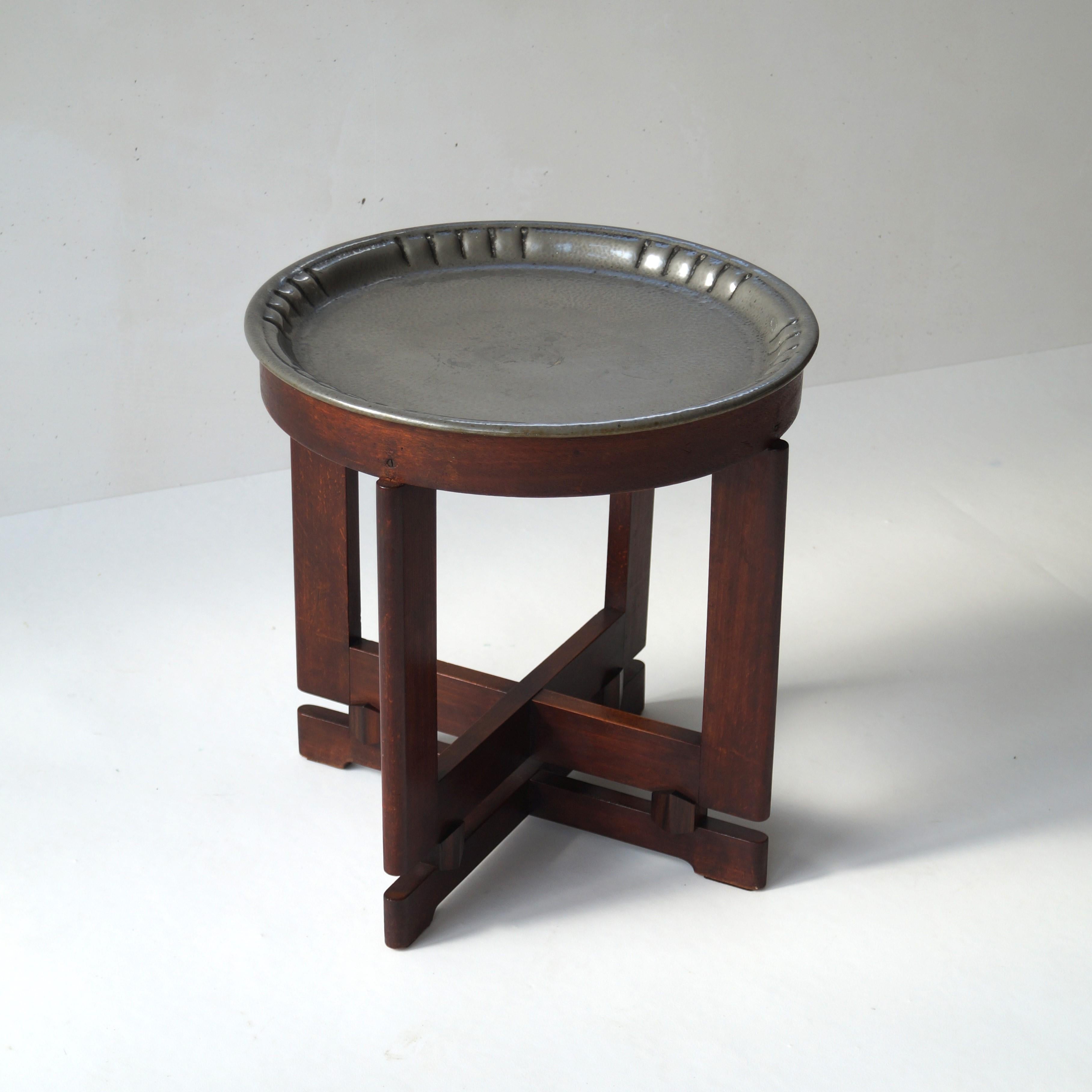 A small Dutch side table Amsterdam School, ca. 1930. Rare design. Originally this table was designed as a smokers' table and it comes with the original pewter top and accessories (an ashtray with a polar bear, a hammered candlestick and a cigar