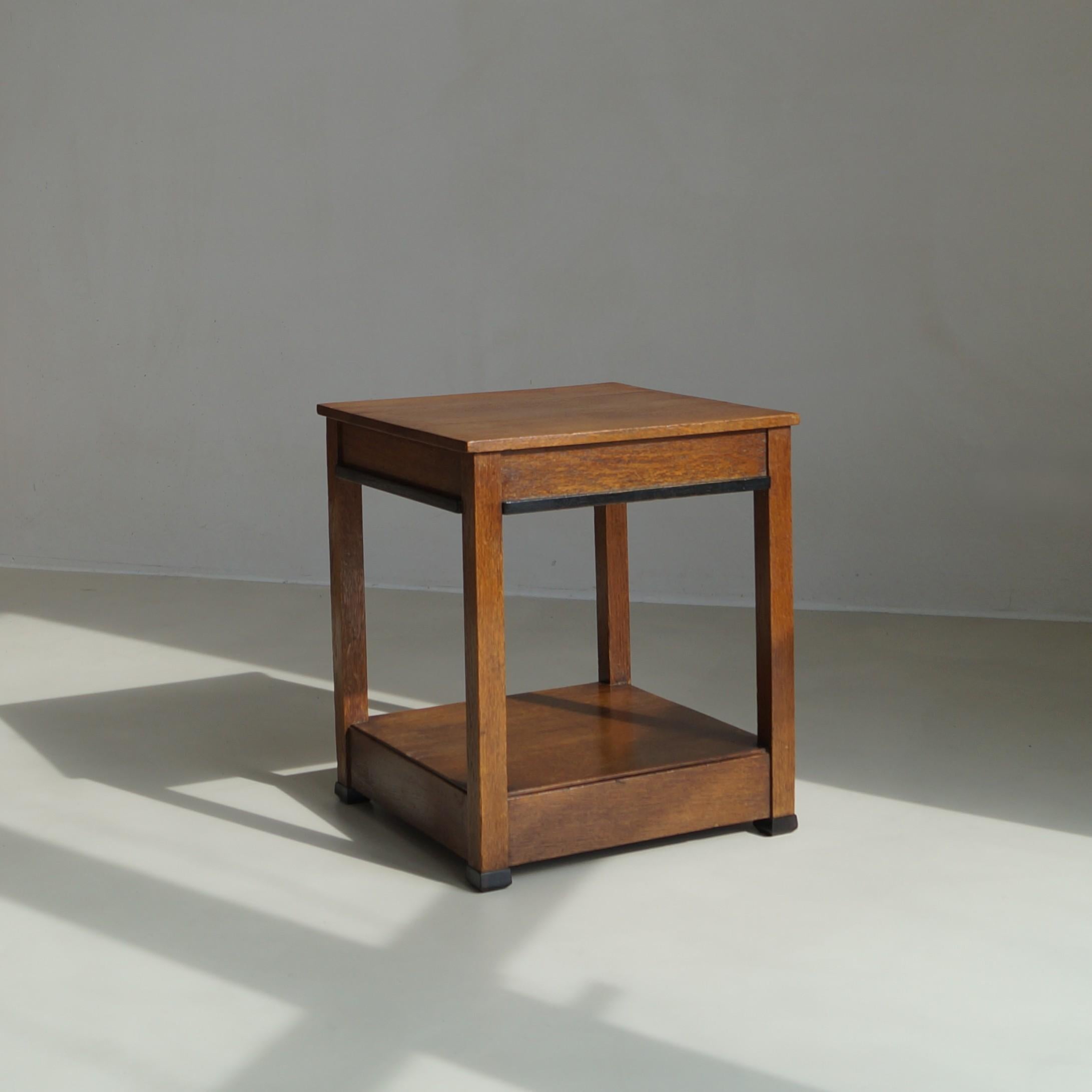 Zweistöckiger Beistelltisch oder Beistelltisch, 1920er Jahre, mit modernistischem Design, zugeschrieben L.O.V. Oosterbeek. Das Stück ist aus Eiche gefertigt und hat schwarz gebeizte Lamellen als modernistisches Detail um die Tischplatte und