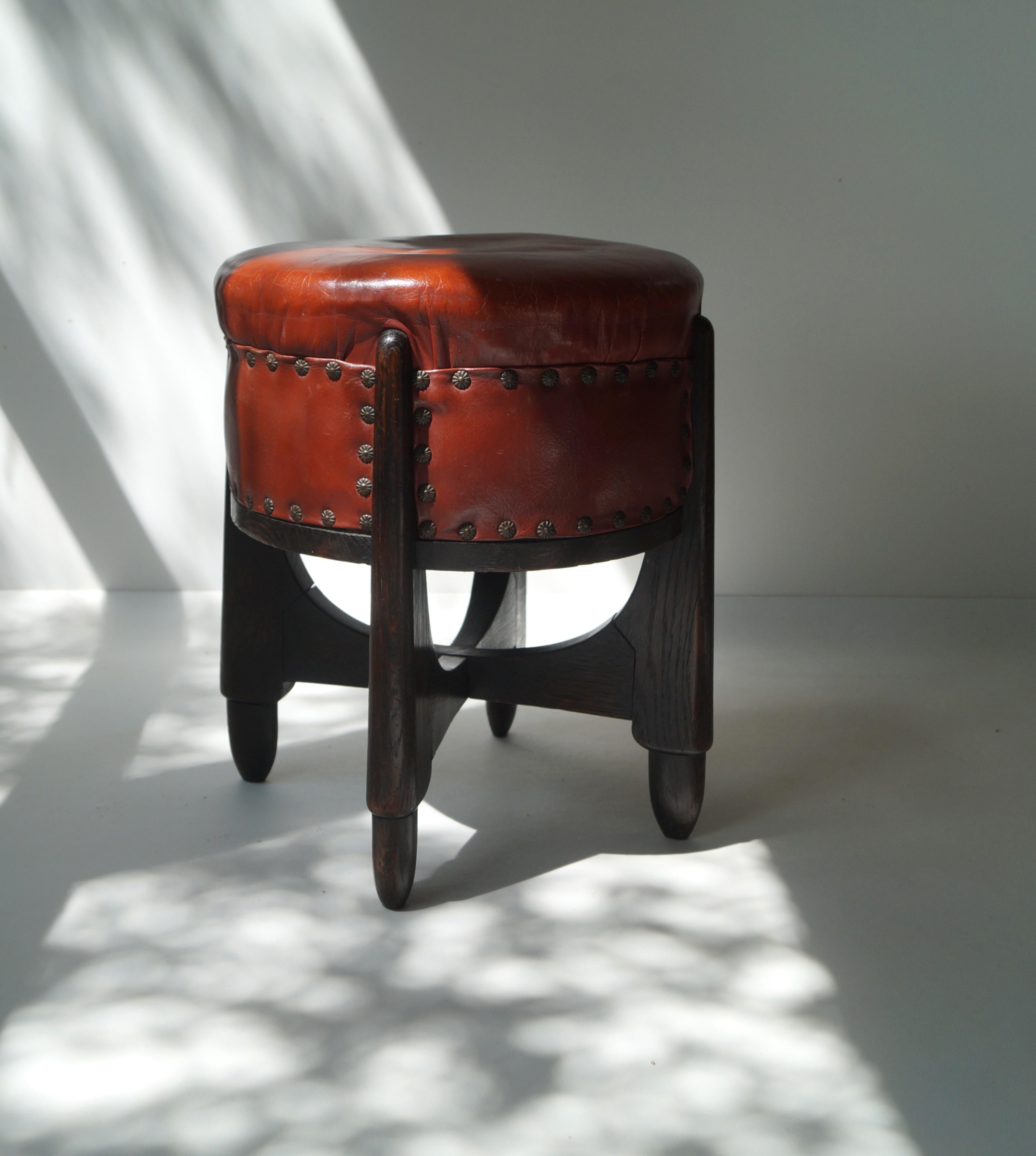 A stylish Amsterdam School stool in solid oak with vintage leather upholstery. These stools were manufactured in the early 1920s for the luxury wallpaper and paint shops Rath & Doodeheefver (see images). Famous Amsterdam School architect Piet Kramer