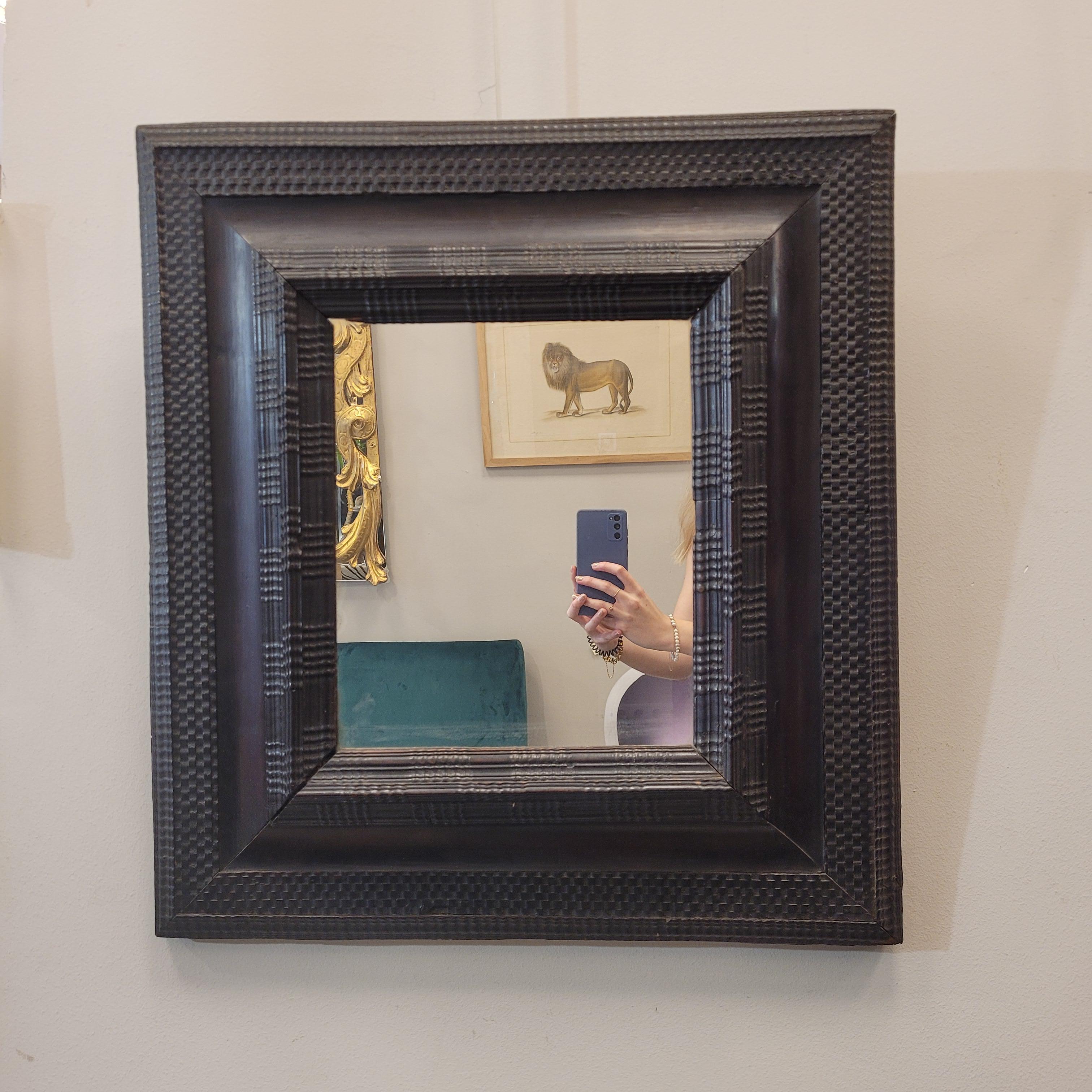 Excelente espejo de estilo barroco holandés con un espectacular marco rectangular de madera ebonizada y tallada con molduras rizadas. El gusto por este tipo de espejos comenzó a lo largo del siglo XVII, pero se siguieron fabricando hasta bien