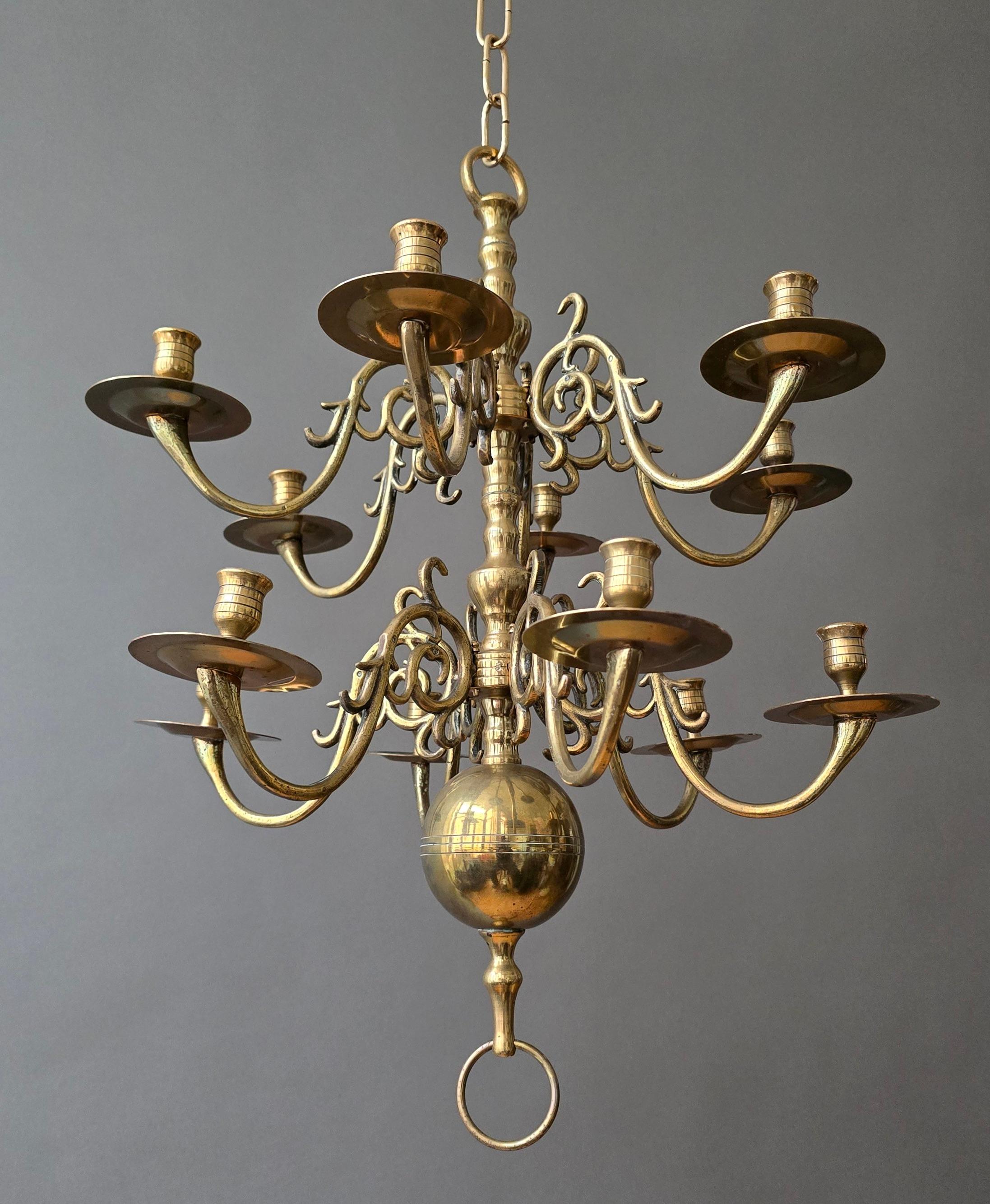 Grande lampadario barocco revival olandese della metà del XIX secolo in ottone massiccio fuso, con dodici portacandele, dettagli finemente torniti, bracci a voluta e la piastra originale in ottone.

Un sostanzioso lampadario barocco olandese della