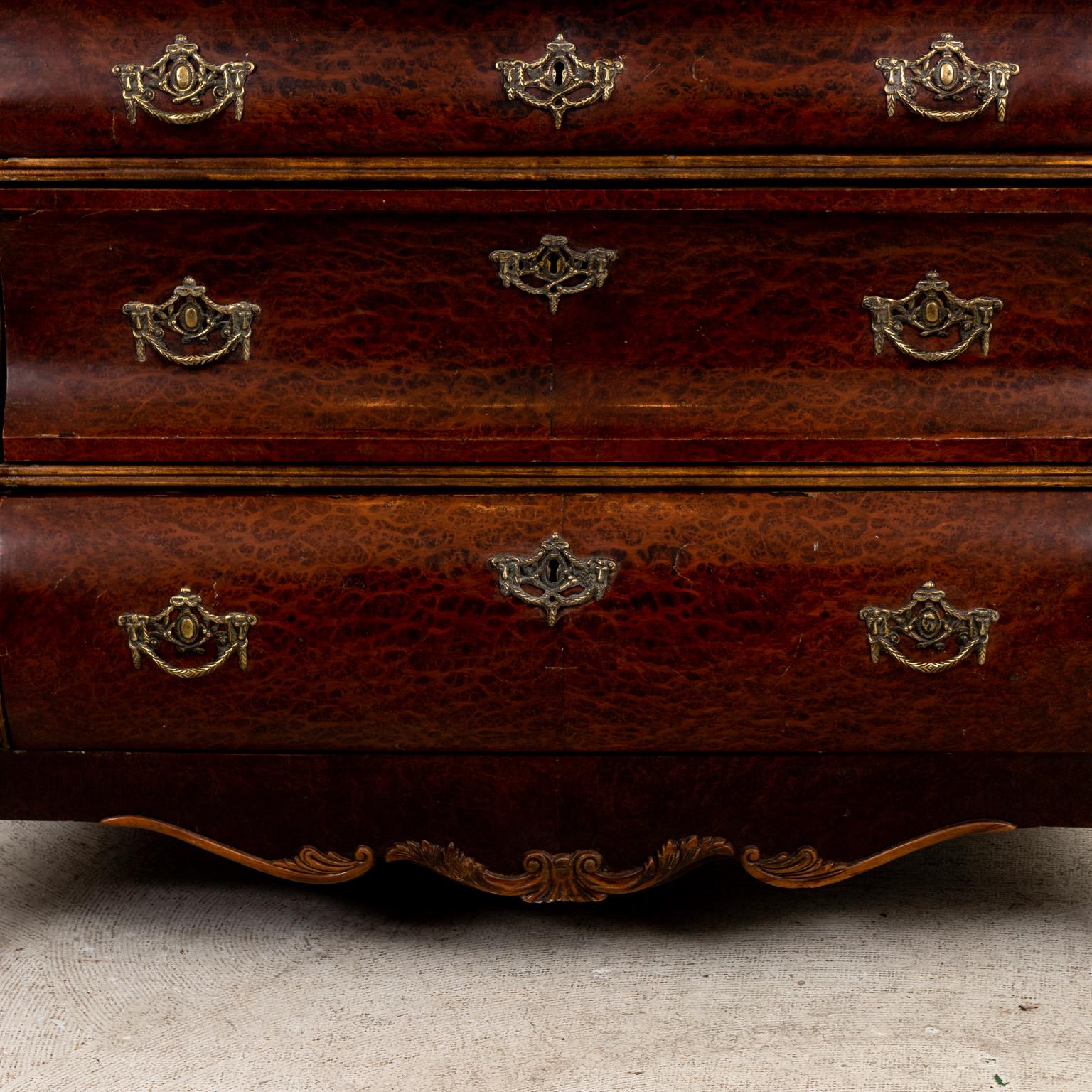 Circa 1920s robust Burlwood chest with three drawers in the Rococo Revival style. Two convex and one concave front on carved, heavy lion's paw feet. The piece also features brass pulls and working key. Made in the Netherlands. Please note of wear