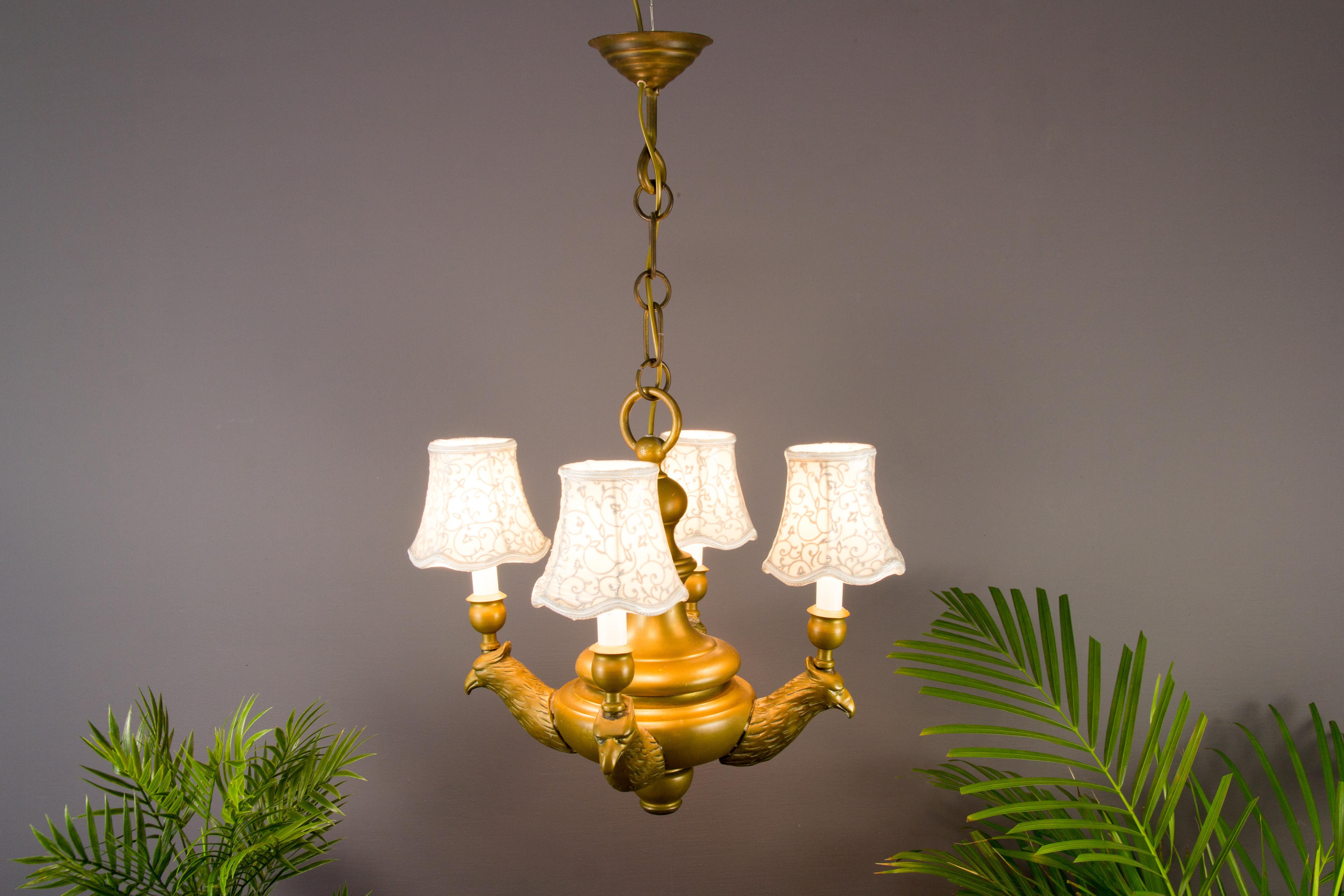 Wonderful bronze four-light chandelier from circa the 1930s. Four beautifully made eagle heads are holding lights with sockets for E 14 light bulbs and a small (new) fabric lampshade.
Dimensions: Diameter: 40 cm / 15.74 in; height: 75 cm / 29.52