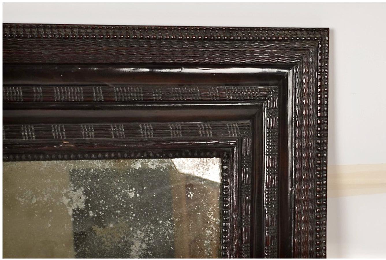 Si tratta di un superbo specchio in stile barocco olandese dell'inizio o della metà del XX secolo. La cornice dello specchio è splendidamente intagliata nell'iconico stile barocco olandese, con un'ampia cornice di 4 pollici decorata con i
