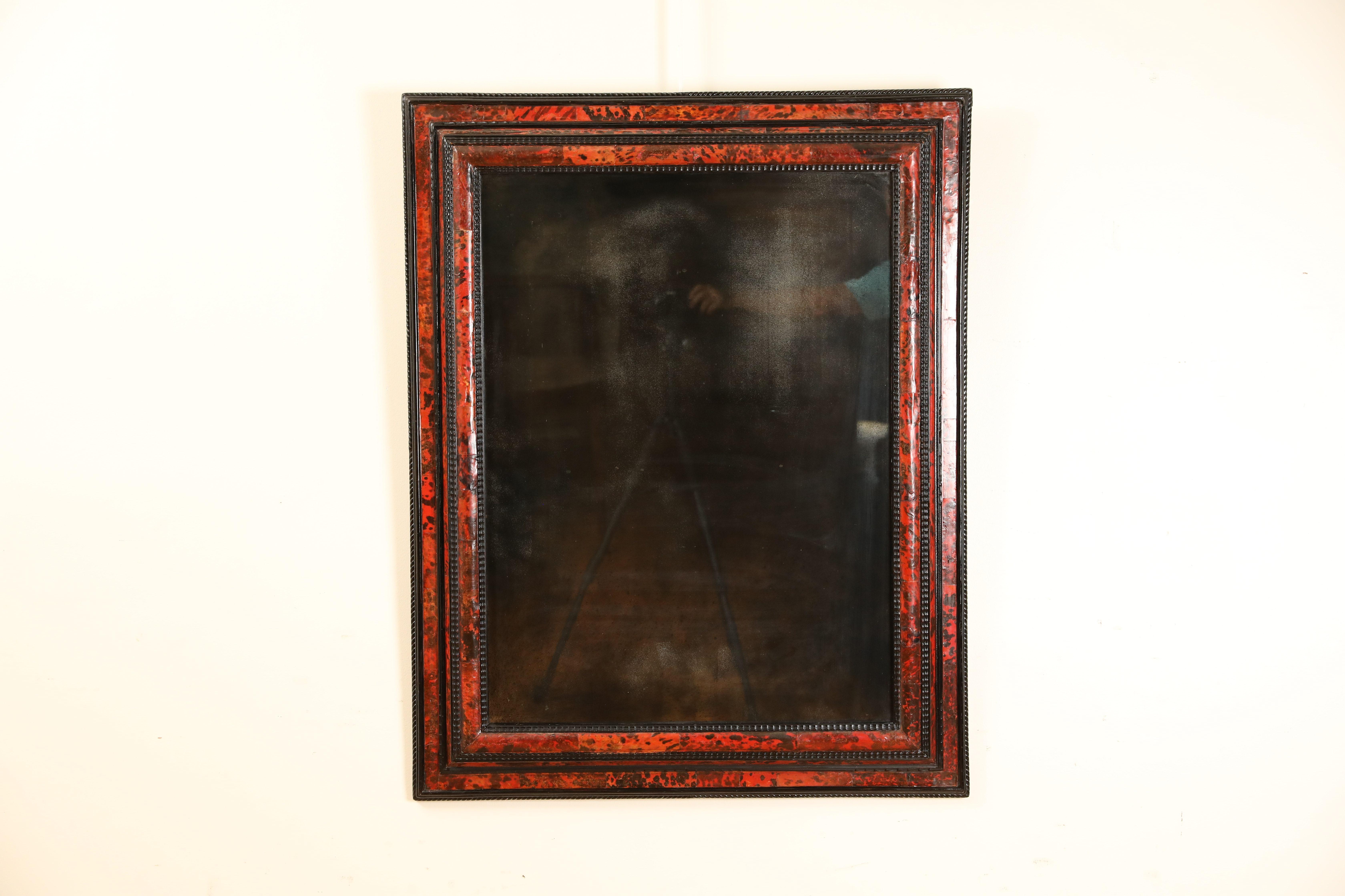 Of rectangular form with varying moldings of ripple and cushion forms, the frame overall with ebonized ground and applied tortoiseshell veneers