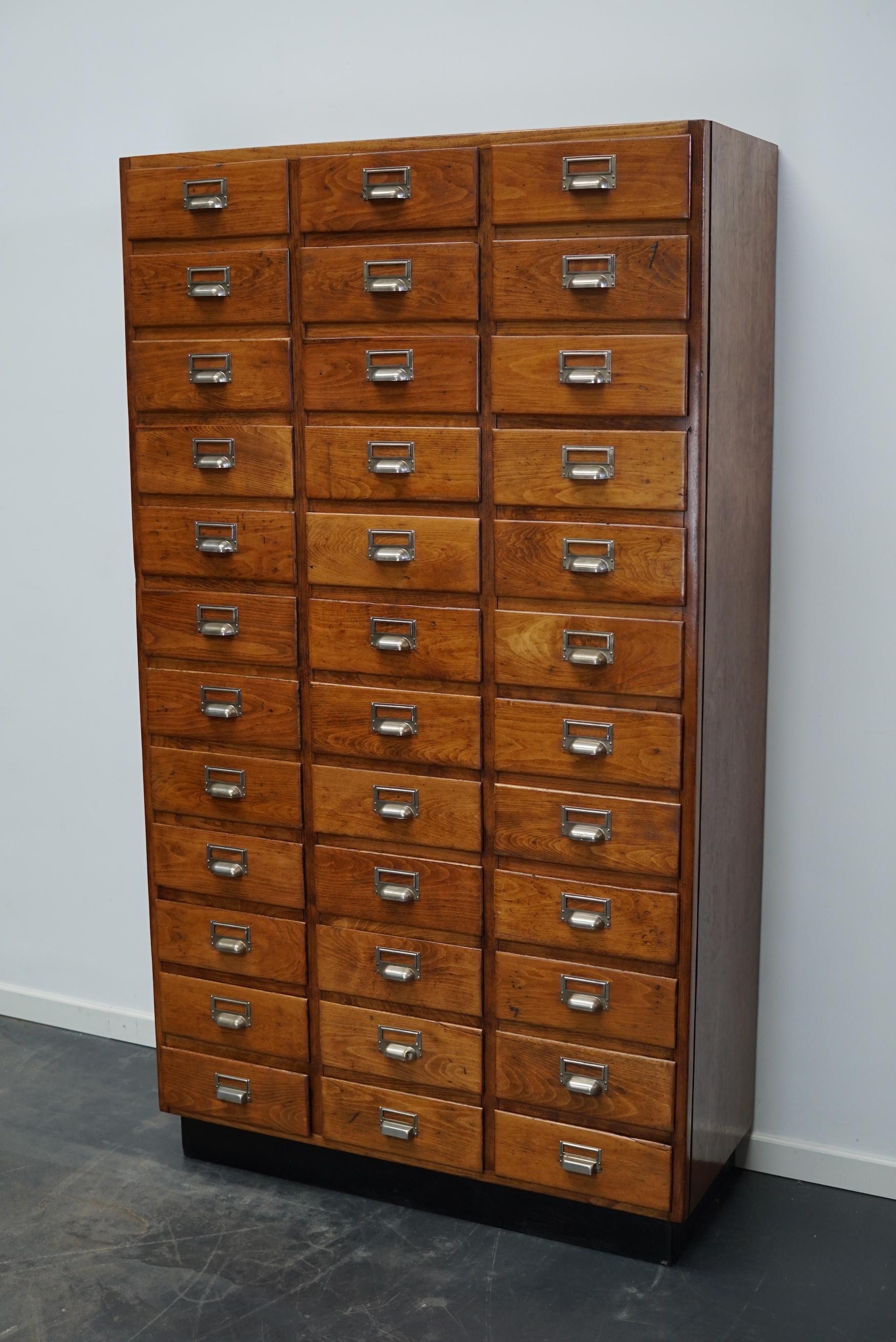 This apothecary cabinet was designed and made from beech circa 1950 in the Netherlands. It features 36 drawers with metal hardware. The inside of the drawers measure: DWH 36 x 26.5 x 9.5 cm.