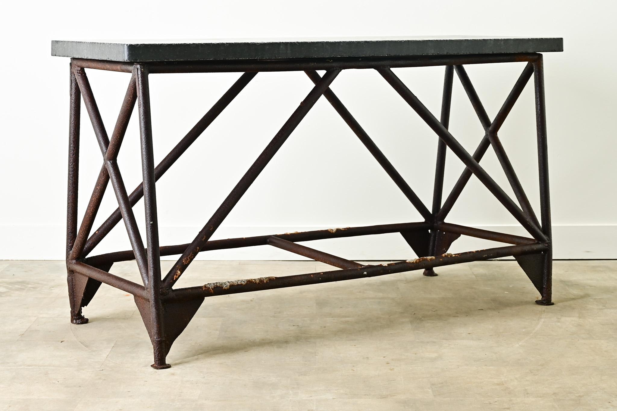 A Belgium Blue Stone and iron console made in the 1800’s. The Belgium blue stone top makes for a durable and usable surface and rests over a heavy iron base with geometric lines and patina only possible with age. This is the perfect console for