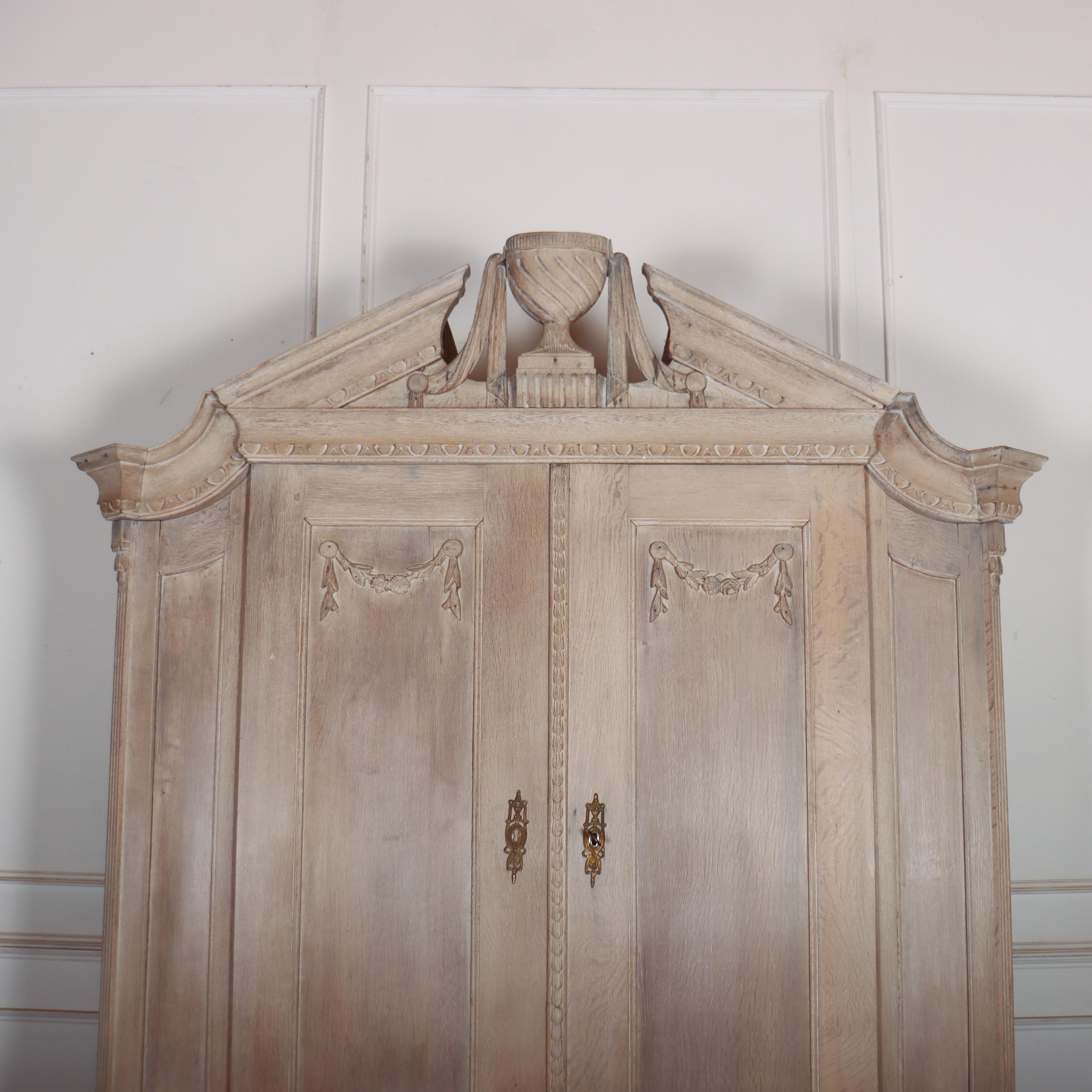 Wonderful 18th century Dutch bleached oak linen cupboard with a broken pediment and carved decoration. 1780. 

Code: 9126

Dimensions:
W: 65