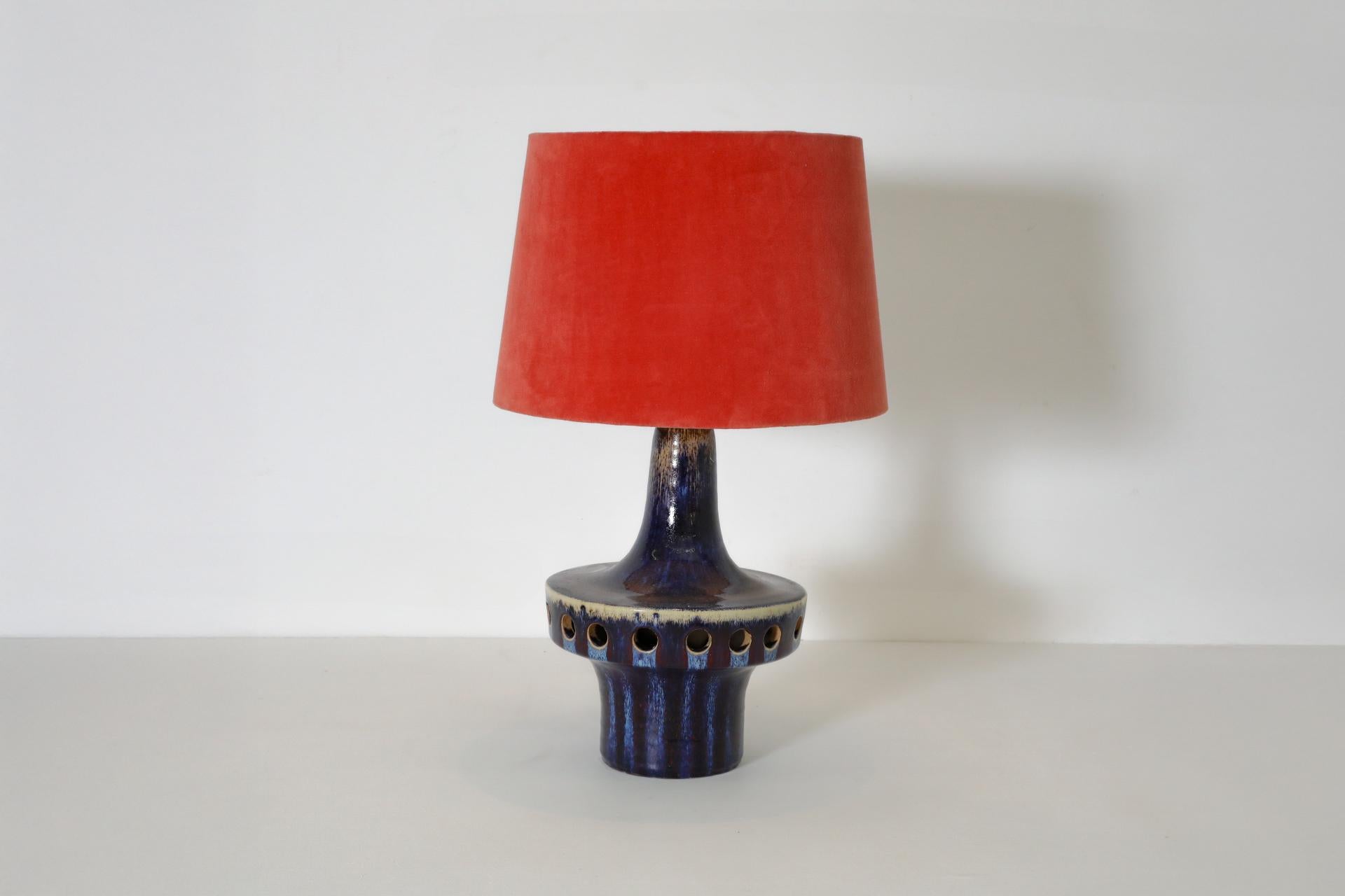 Mid-Century Dutch blue glazed ceramic table lamp with cut-outs and fun red shade. Jaap Ravelli (1916–2011), a Dutch ceramicist, is well known for the modern, minimalist ceramics with organic shapes and matte glazes created by his studio in the 1950s