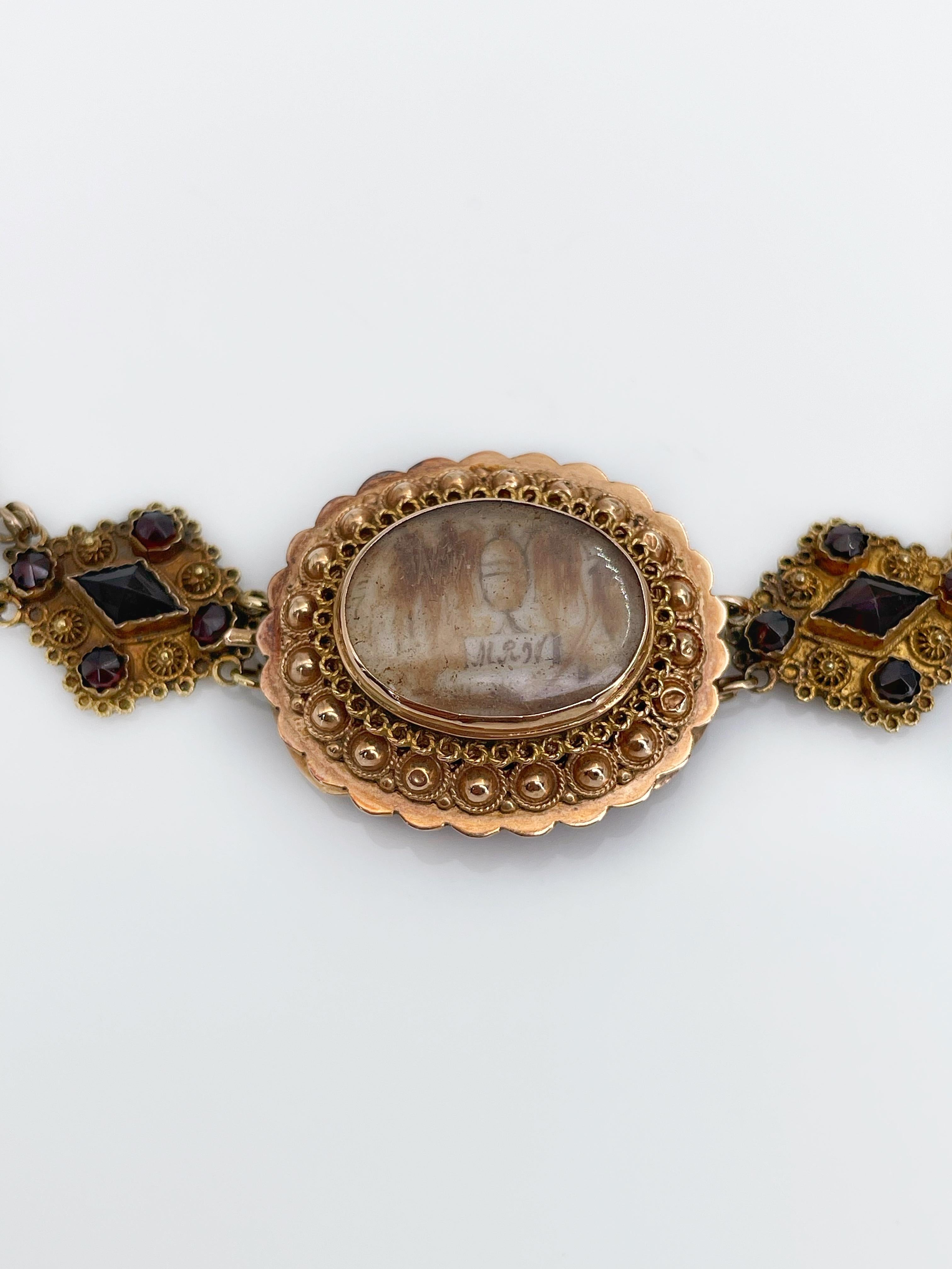 Necklace: The antique filigree 14 Karat gold and garnets necklace composed of nine oval facetted garnets, two drop shape facetted garnets and ten golden flowers includes seven small garnets in each of them, a couple of rhombus parts beside the clasp