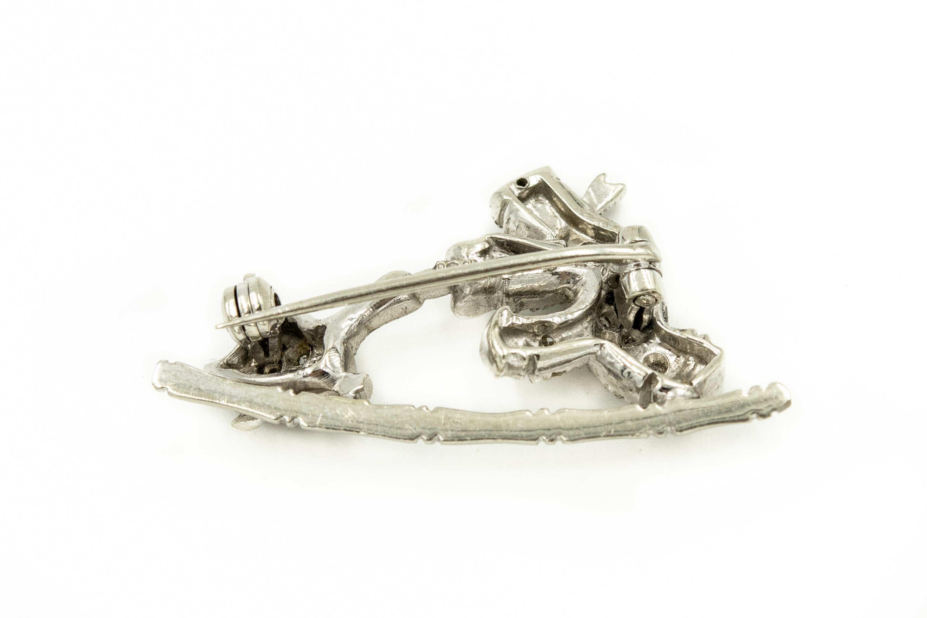 Whimsical 18k white gold brooch featuring a Dutch boy playing with a goose.