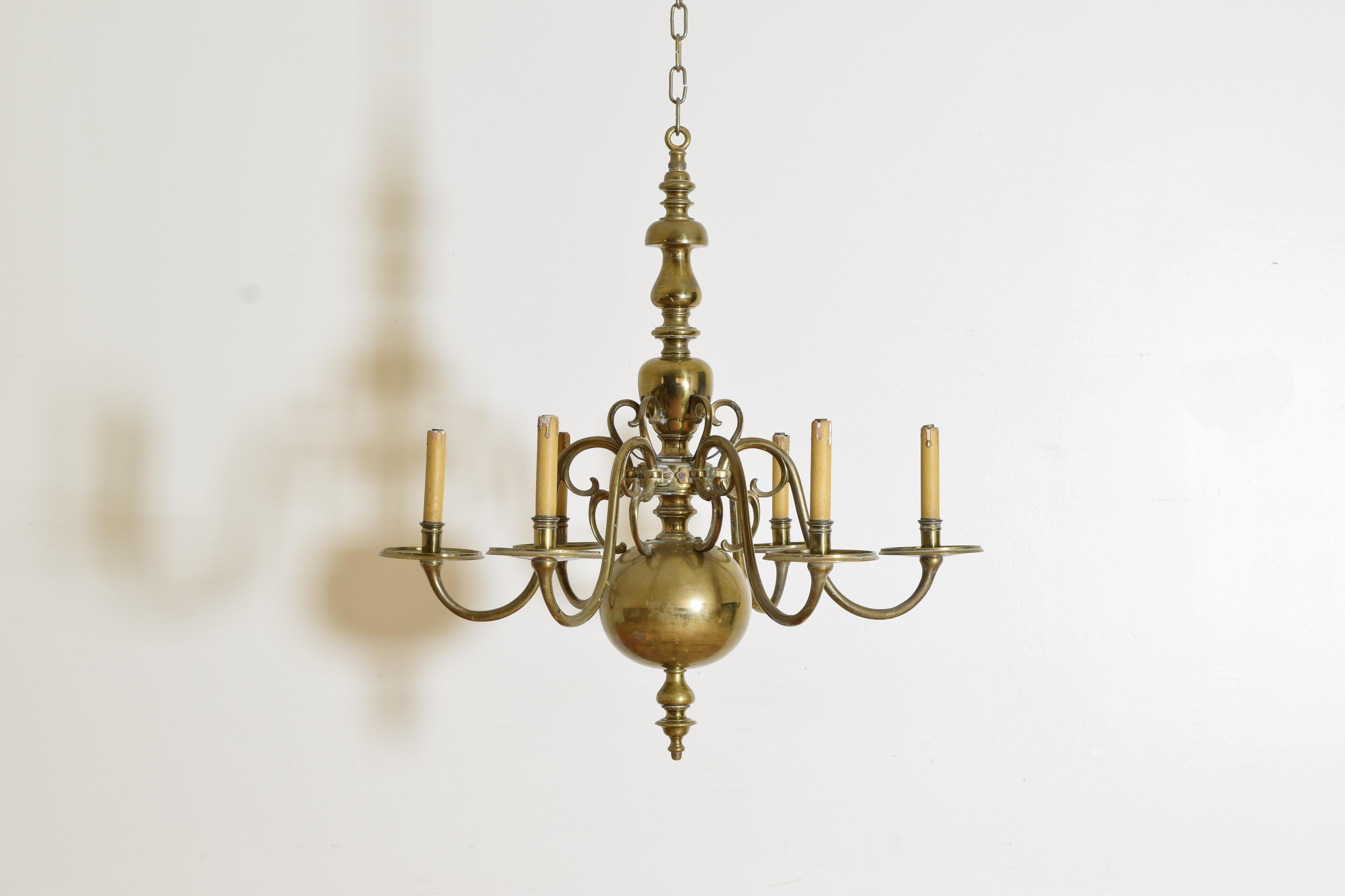 Constructed entirely of brass and of sizable scale and weight this classic chandelier in the Dutch manner has a shaped standard issuing 6 scrolling arms, the arms hollow with later drillings of the collector to bring to internalize the later wiring 